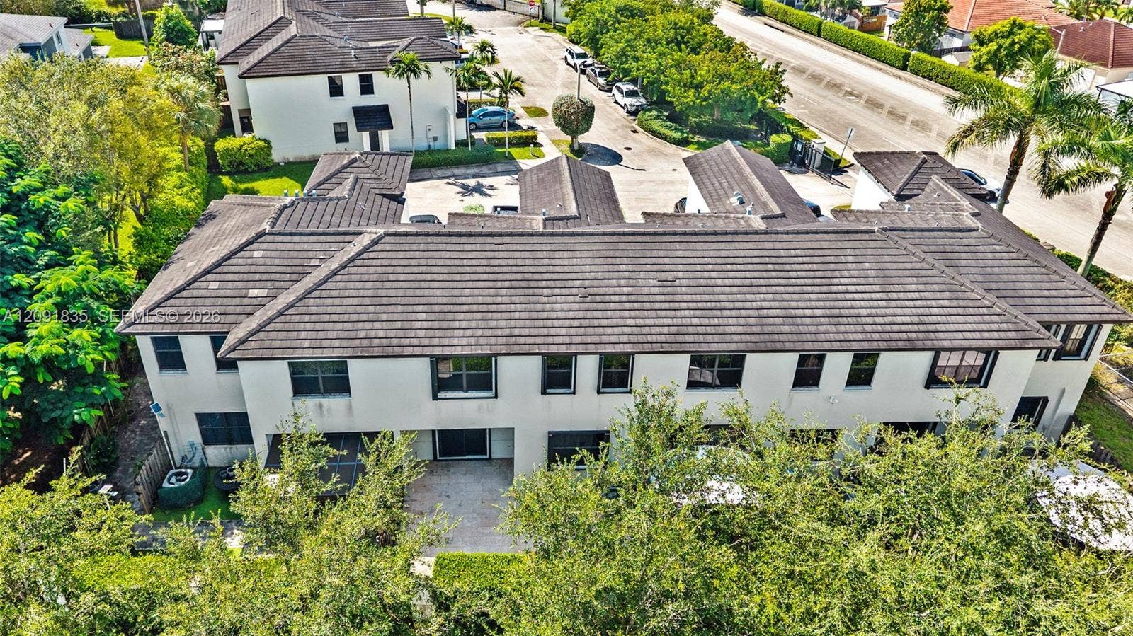 22409 SW 102nd Avenue, Miami, FL 33190 Multi-level exterior featuring a hipped tile roof, smooth stucco facade, and paved patio area