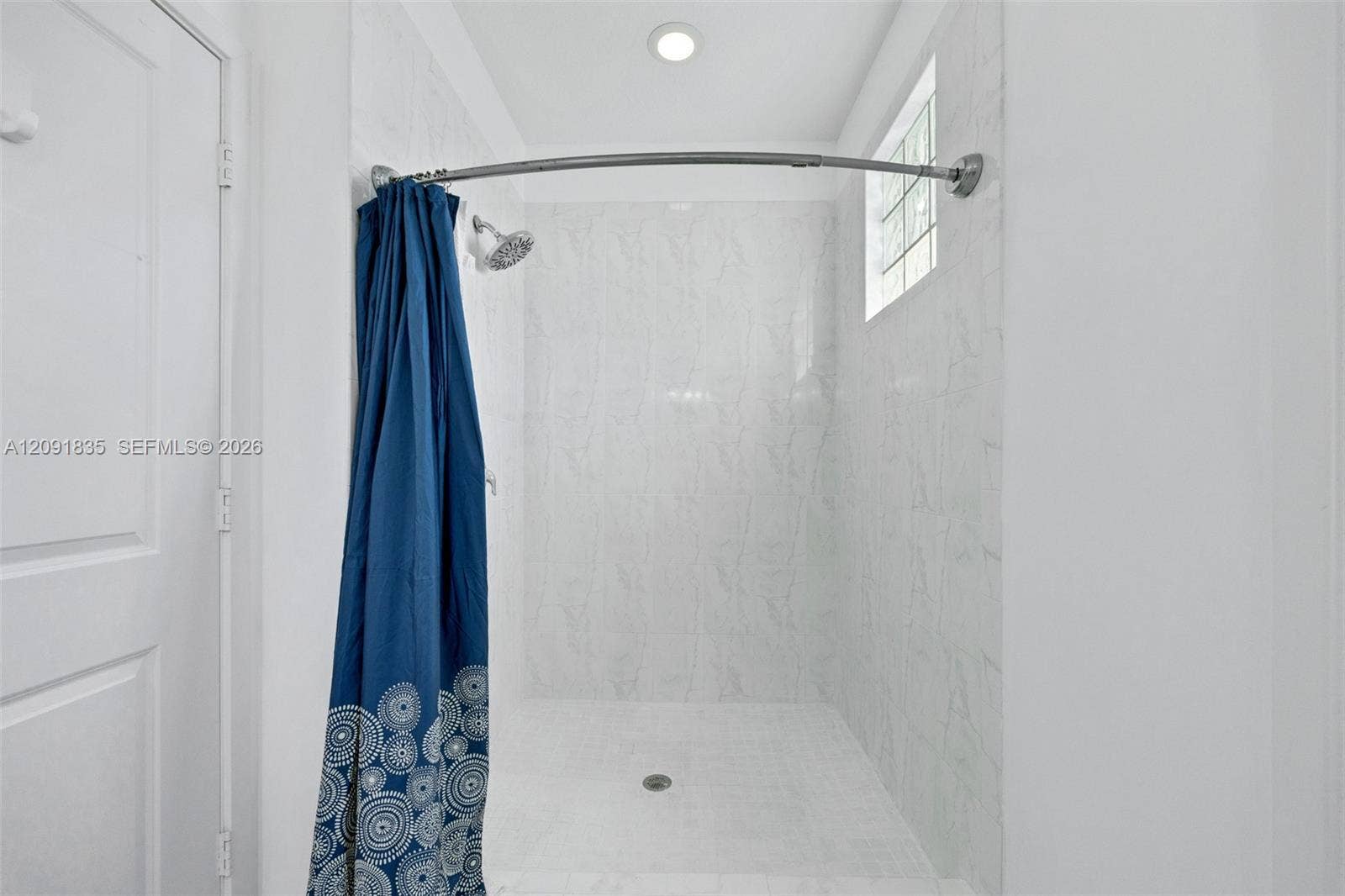 22409 SW 102nd Avenue, Miami, FL 33190 Walk-in shower featuring white stone-finish wall tile, recessed ceiling lighting, a fixed shower head, and a glass block window