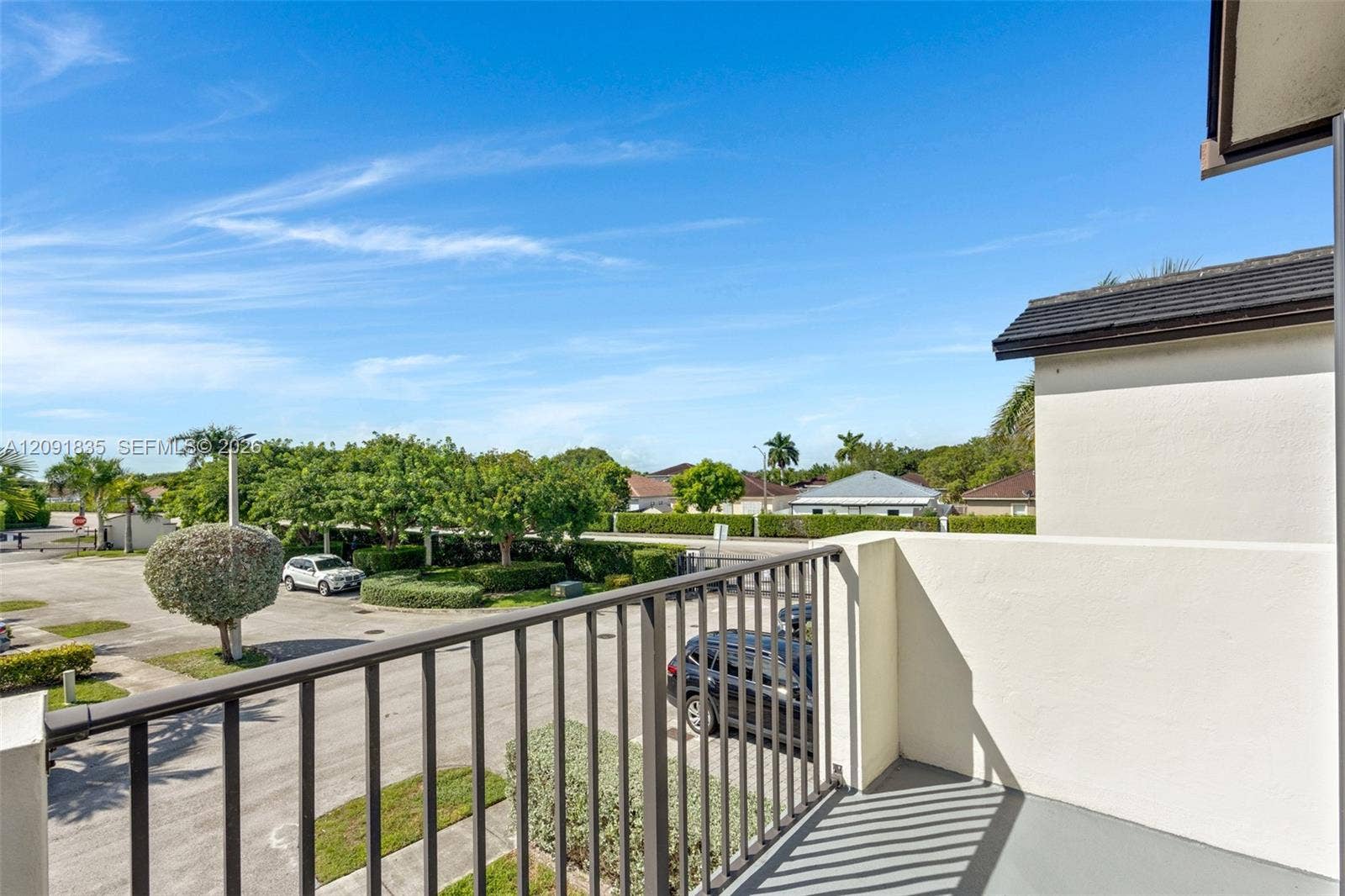 22409 SW 102nd Avenue, Miami, FL 33190 Elevated outdoorvered balcony with smooth-finish concrete balcony featuring solid wall privacy screening and a metal railing