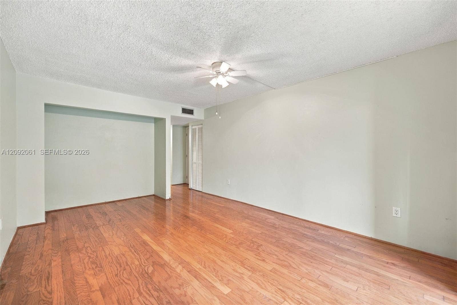 6555 W Broward Boulevard, #309, Plantation, FL 33317 Spacious interior featuring wood-finish flooring, a ceiling fan with integrated lighting, and neutral wall paint