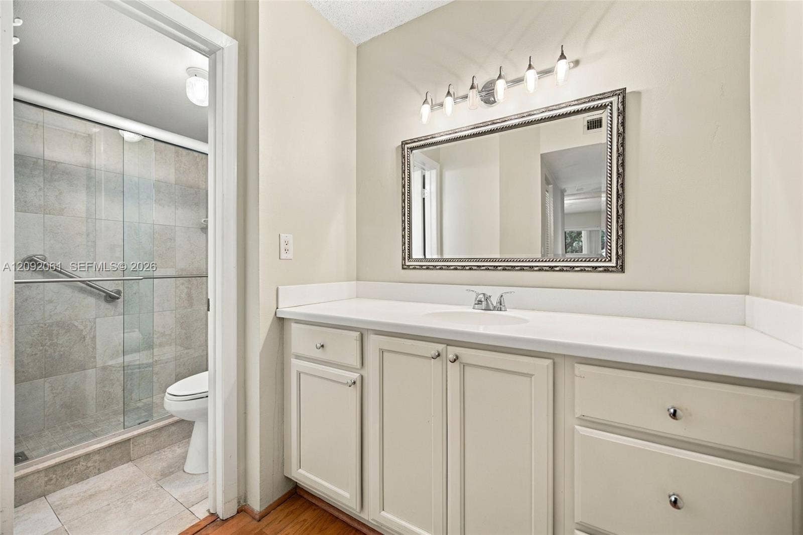 6555 W Broward Boulevard, #309, Plantation, FL 33317 Bathroom featuring a vanity with neutral cabinetry, solid-surface countertop, rectangular basin, and five-light fixture