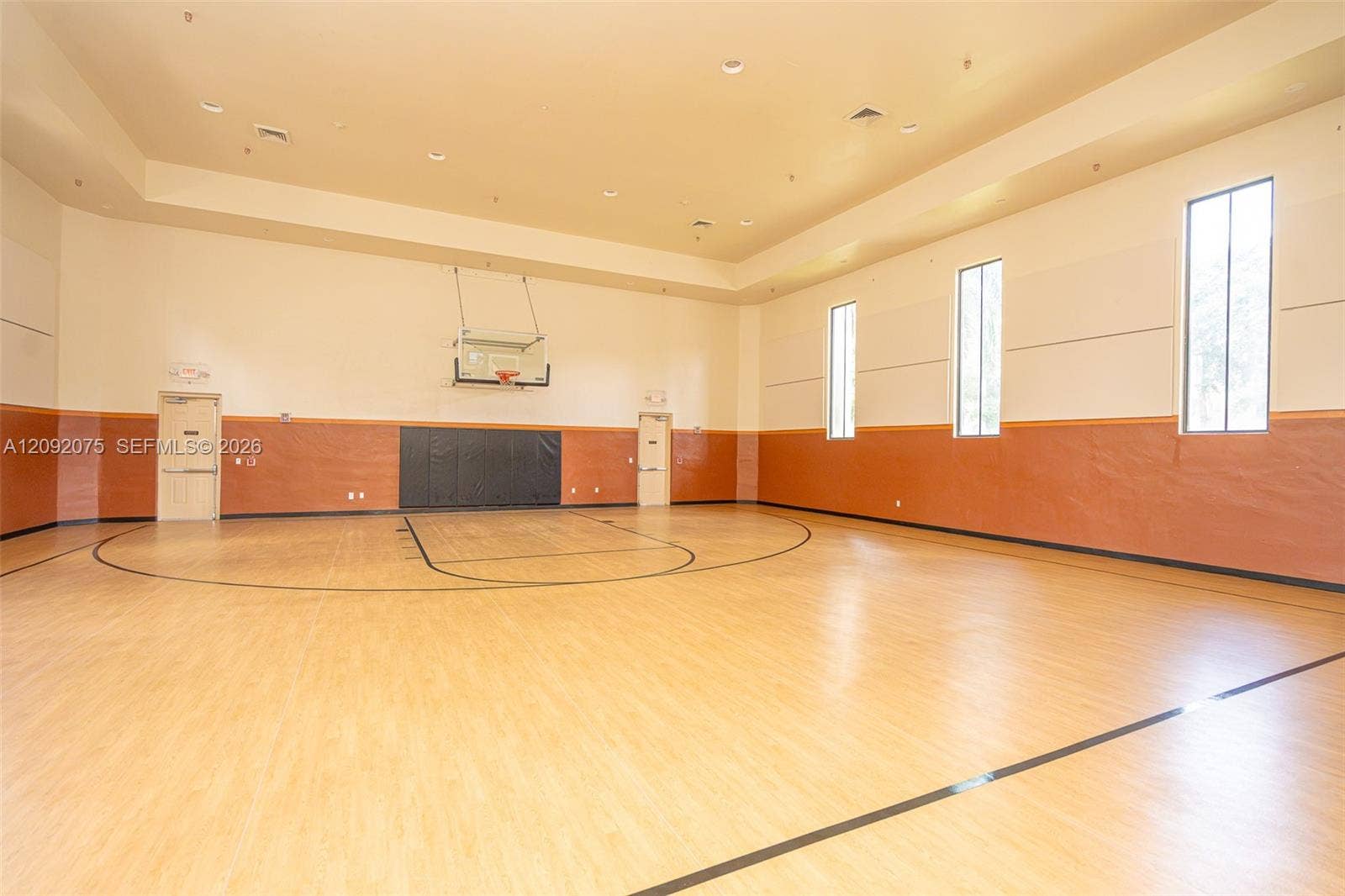 3055 NW 126th Avenue, #219, Sunrise, FL 33323 Indoor court with light wood-finish flooring, high ceilings, multiple windows, and recessed lighting