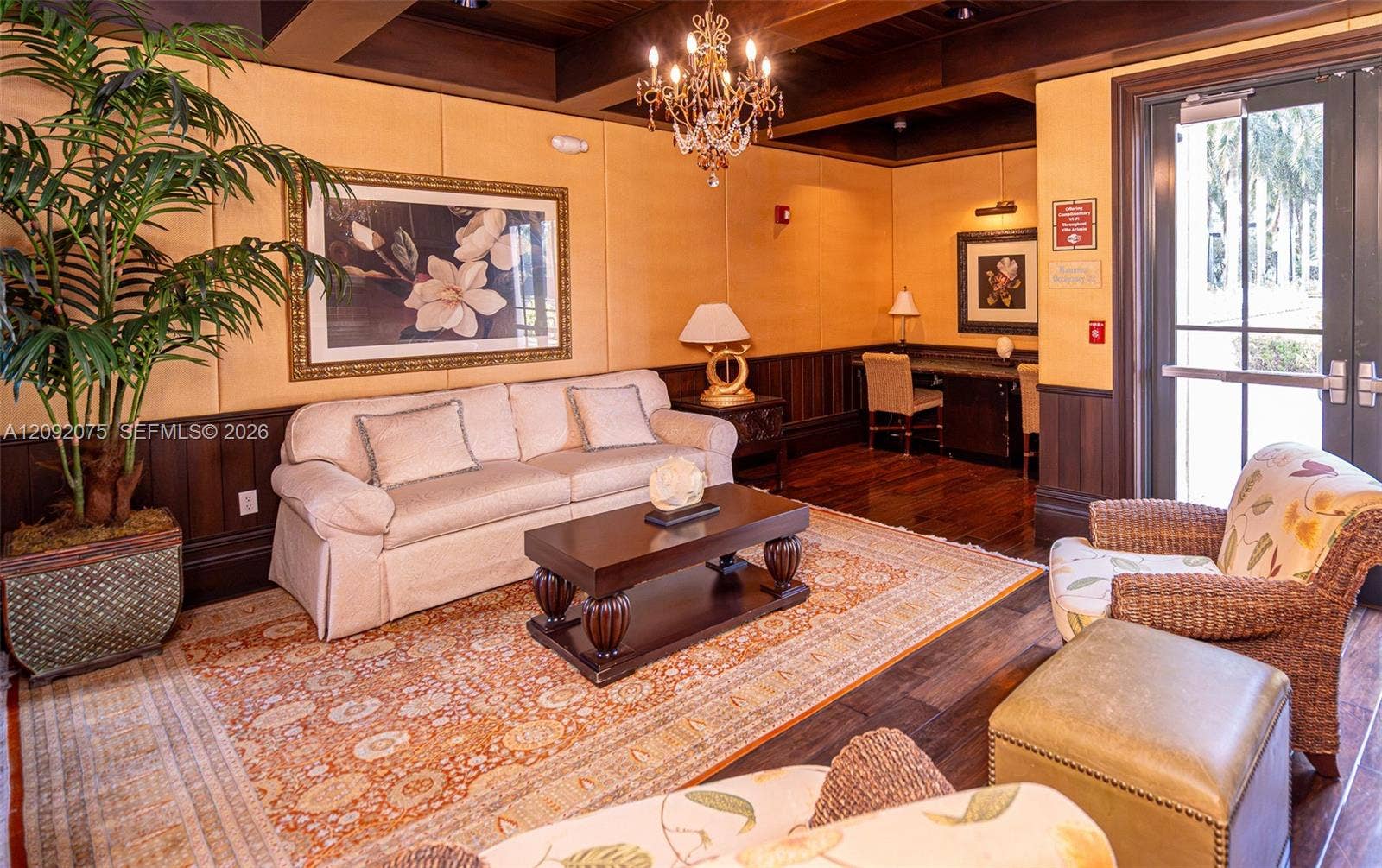 3055 NW 126th Avenue, #219, Sunrise, FL 33323 Wood-finish flooring, dark wood wainscoting, and a chandelier with decorative accents