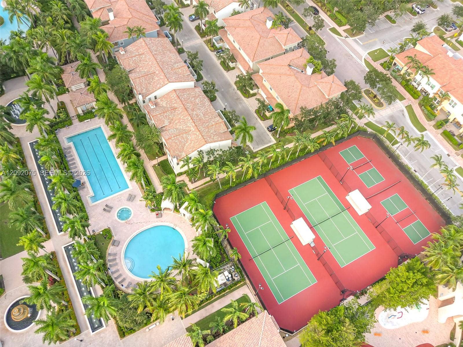 3055 NW 126th Avenue, #219, Sunrise, FL 33323 Outdoor amenities featuring multiple swimming pools, a spa, and tennis courts set among lush landscaping