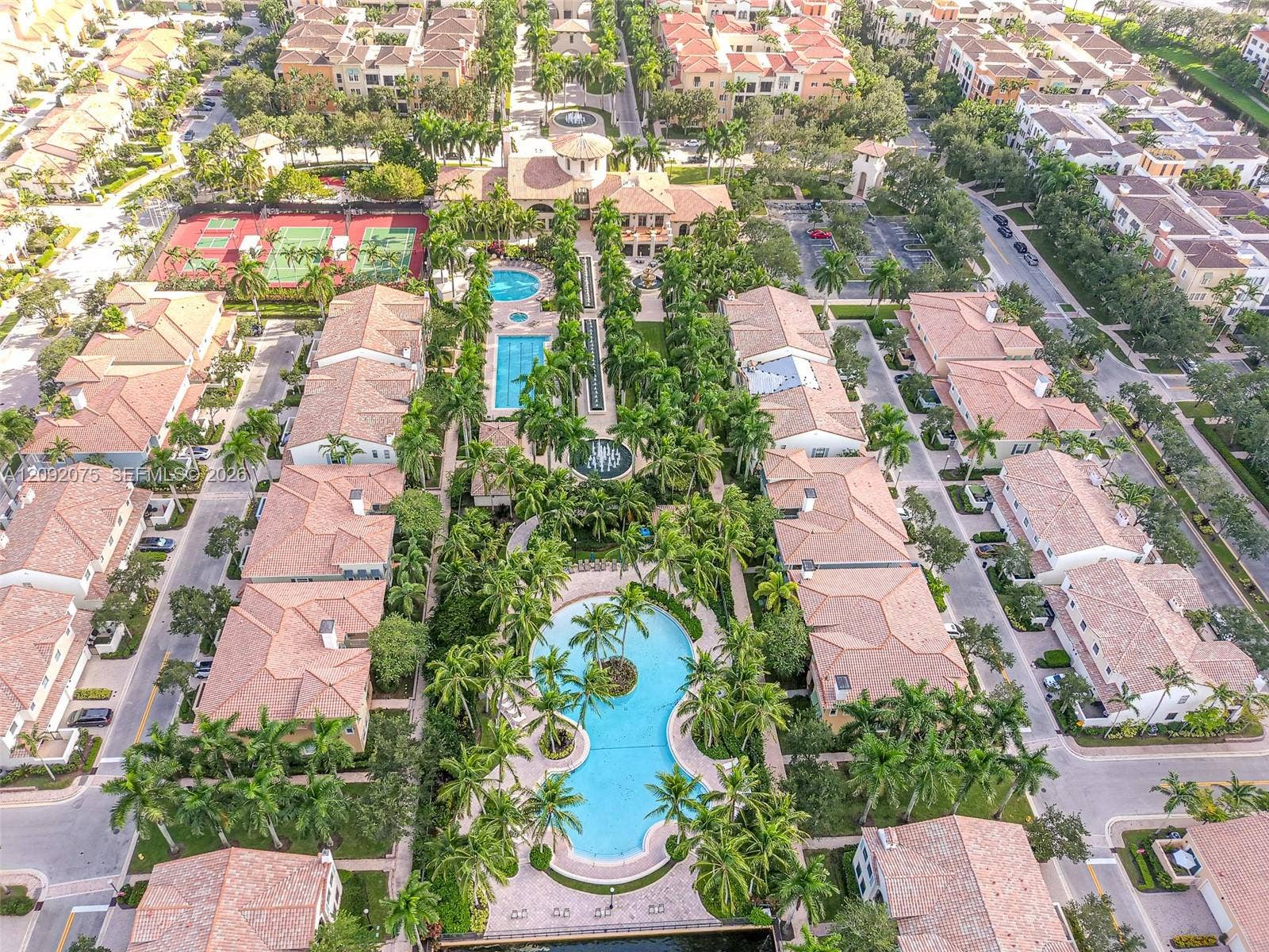 3055 NW 126th Avenue, #219, Sunrise, FL 33323 Community featuring multiple swimming pools, tennis courts, and mature landscaping with palm trees