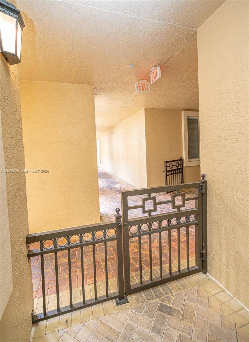 3055 NW 126th Avenue, #219, Sunrise, FL 33323 Brick paver flooring with a dark bronze decorative metal gate