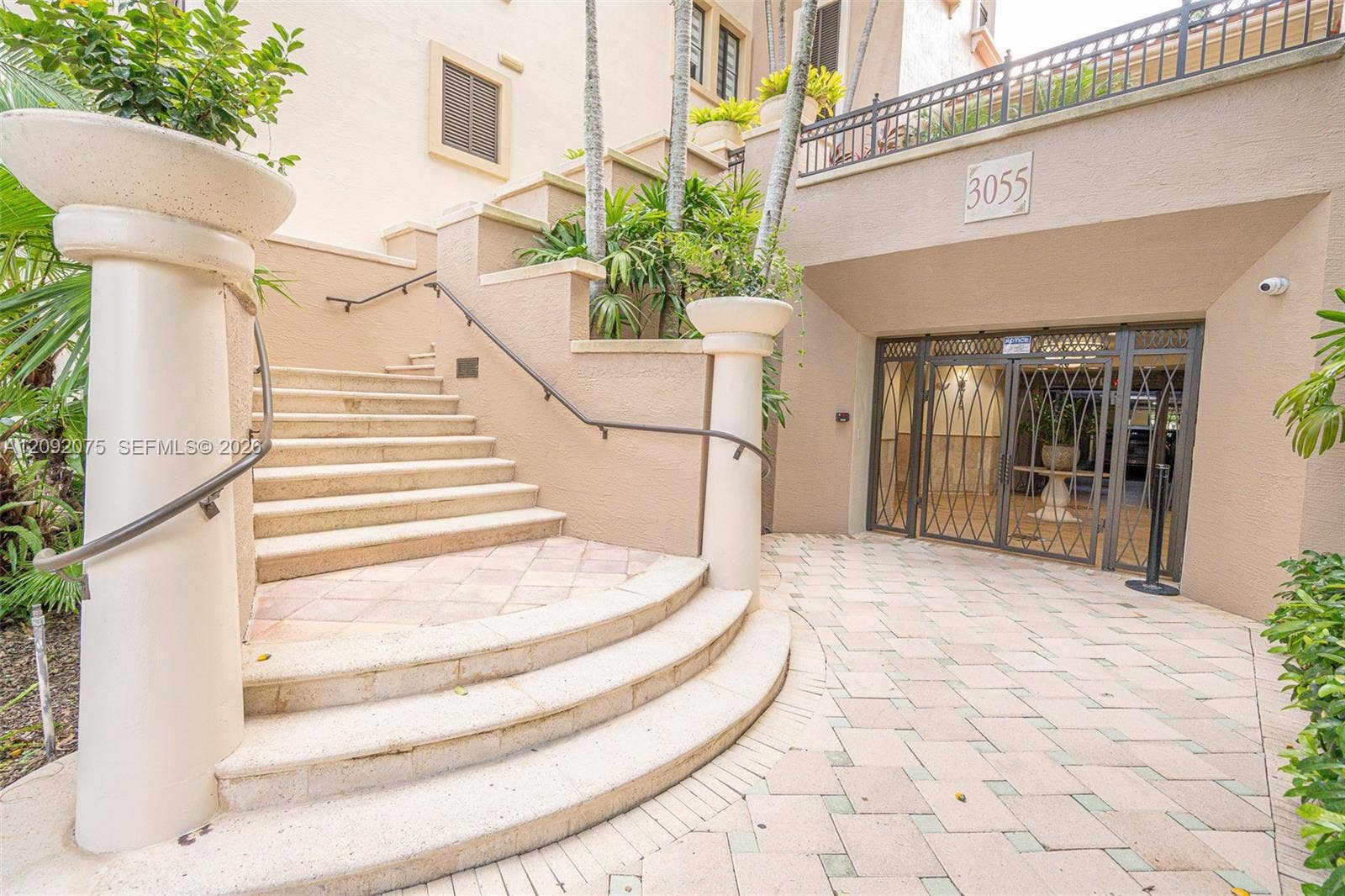 3055 NW 126th Avenue, #219, Sunrise, FL 33323 Tiered staircase with wrought iron handrails, leading to an entrance with security gates