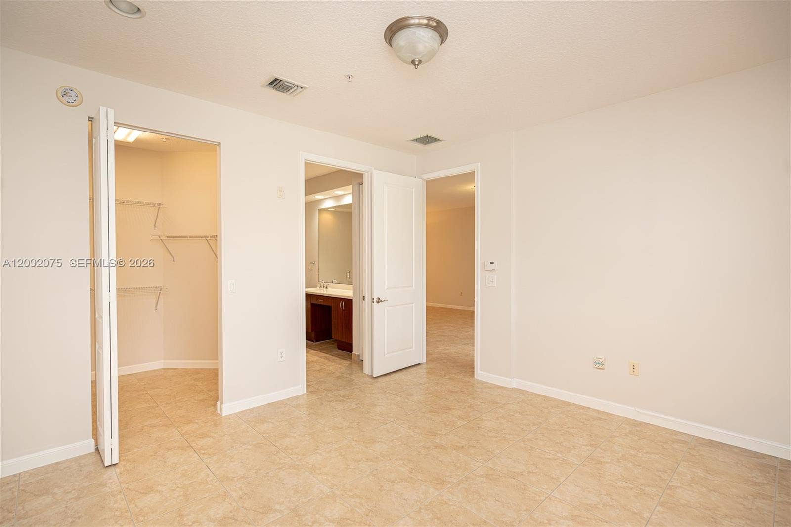 3055 NW 126th Avenue, #219, Sunrise, FL 33323 Light-toned tile flooring, neutral wall paint, and a built-in closet with shelving