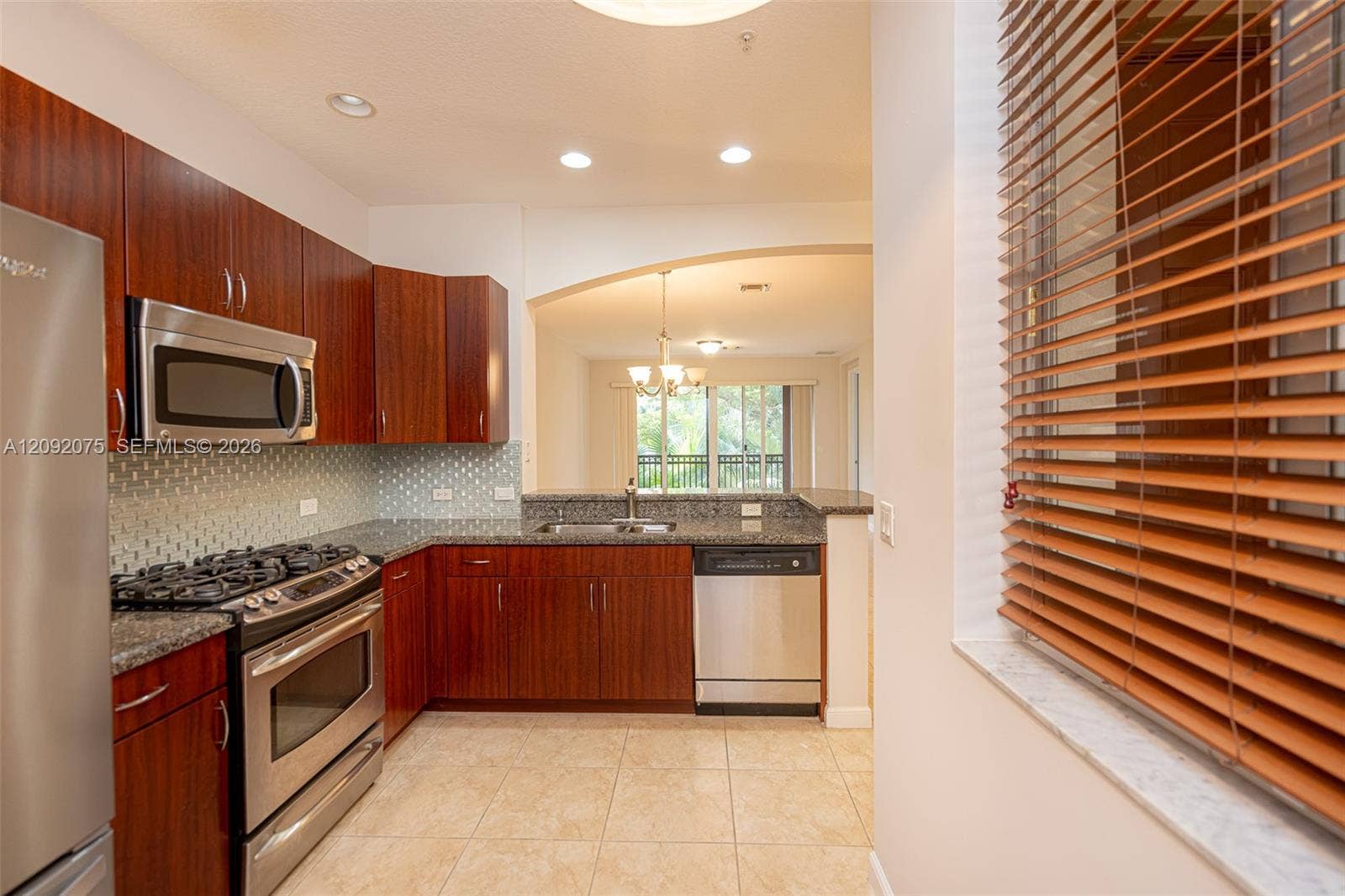 3055 NW 126th Avenue, #219, Sunrise, FL 33323 Full-sized kitchen with stainless steel appliances, granite countertops, and tile flooring