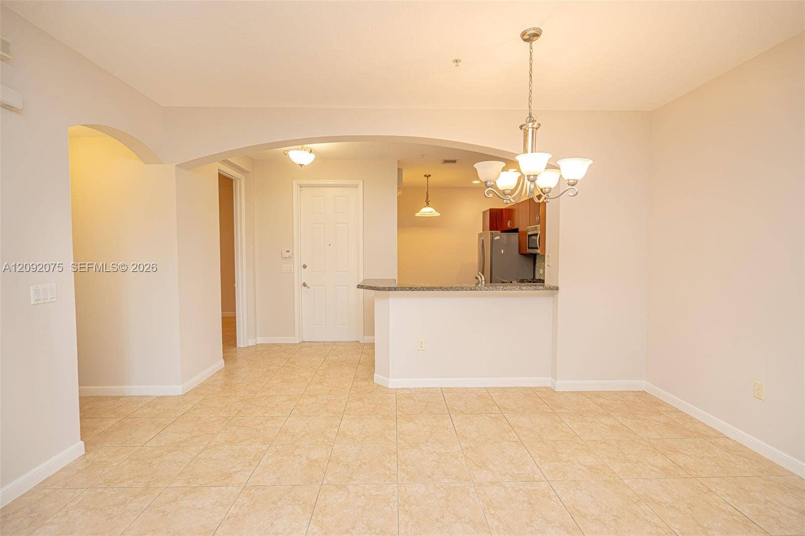 3055 NW 126th Avenue, #219, Sunrise, FL 33323 Tile flooring, overhead chandelier, arched doorways, breakfast bar, and stainless-steel appliances