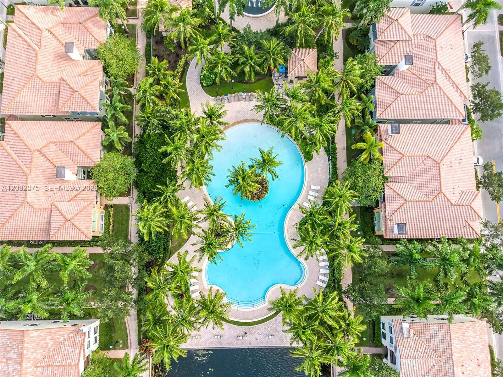 3055 NW 126th Avenue, #219, Sunrise, FL 33323 Resort-style pool with integrated island landscaping, surrounded by mature palm trees