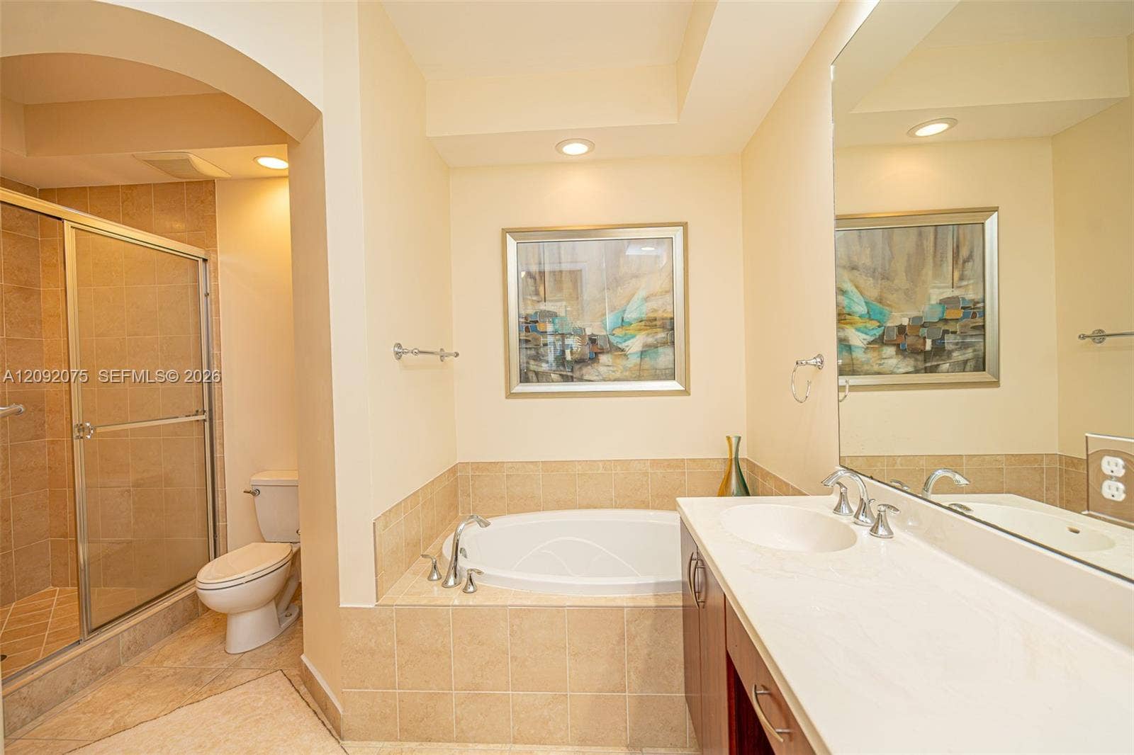 3055 NW 126th Avenue, #219, Sunrise, FL 33323 Recessed lighting, arched doorway, fully tiled shower with glass enclosure, soaking tub, and dual vanity with integrated sinks