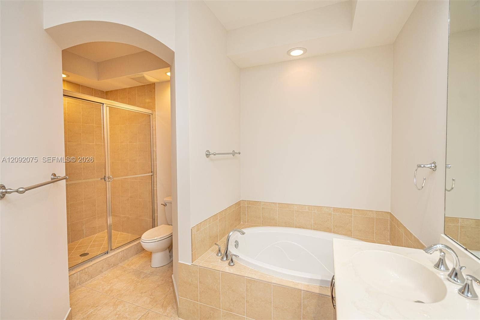 3055 NW 126th Avenue, #219, Sunrise, FL 33323 Recessed lighting, arched doorway, tile flooring, built-in bathtub, and a glass-enclosed shower