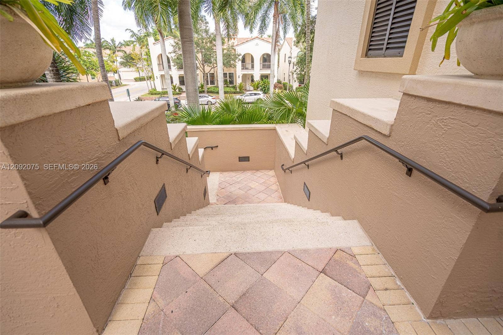 3055 NW 126th Avenue, #219, Sunrise, FL 33323 Exterior staircase with stucco walls, integrated wall lighting, and wrought iron handrails
