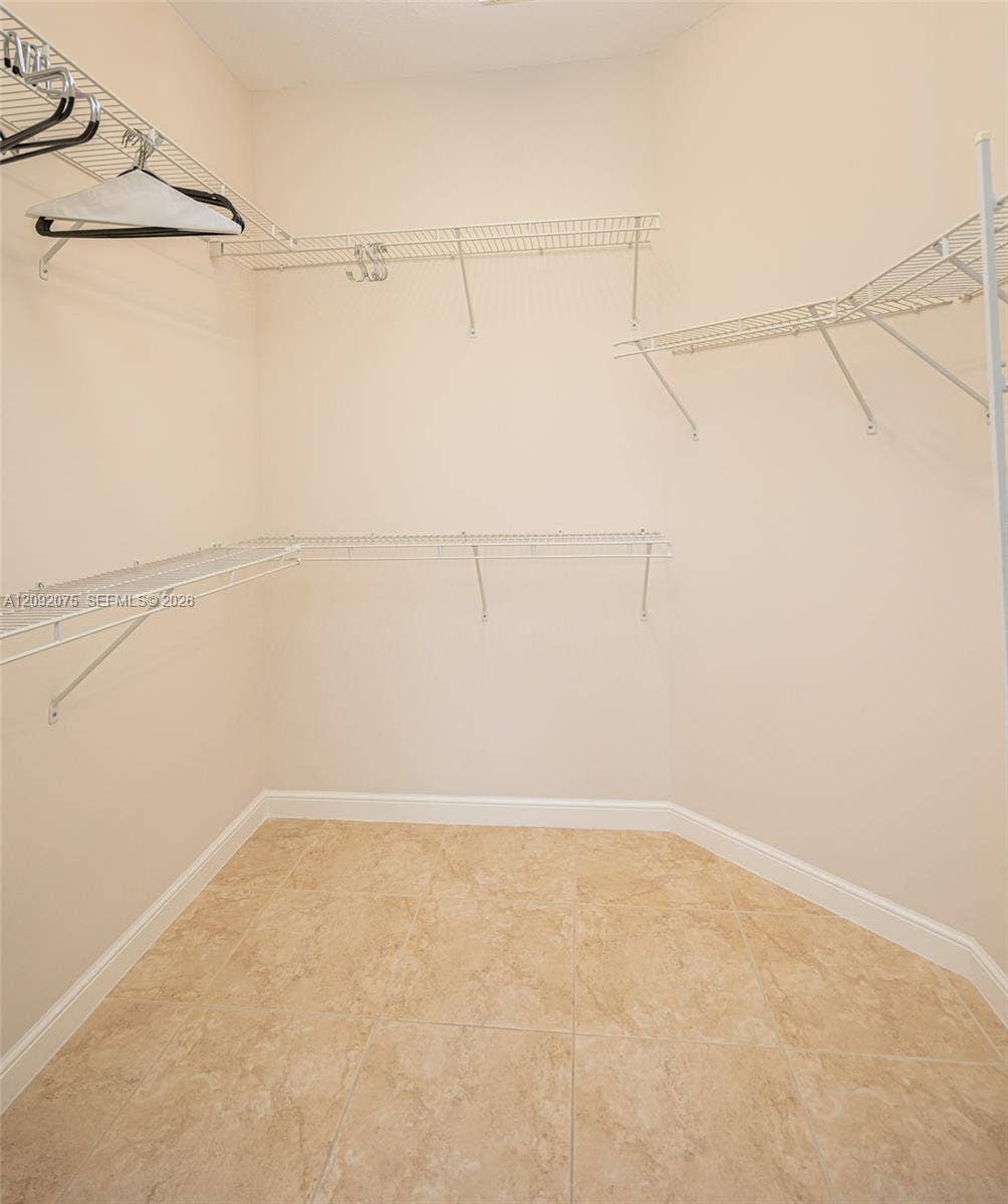 3055 NW 126th Avenue, #219, Sunrise, FL 33323 Spacious walk-in closet featuring wire shelving, wire hanging rods, and tile flooring