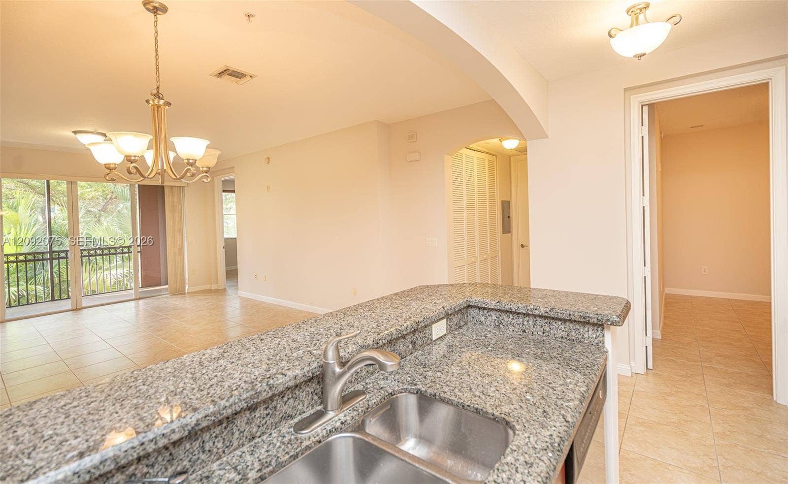 3055 NW 126th Avenue, #219, Sunrise, FL 33323 Kitchen counter with a double stainless steel sink, granite-finish countertop, and a chrome faucet