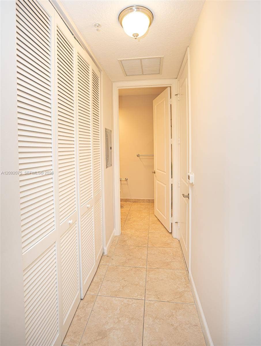 3055 NW 126th Avenue, #219, Sunrise, FL 33323 Recessed ceiling light fixture, louvered bi-fold closet doors, tile flooring, and white interior doors