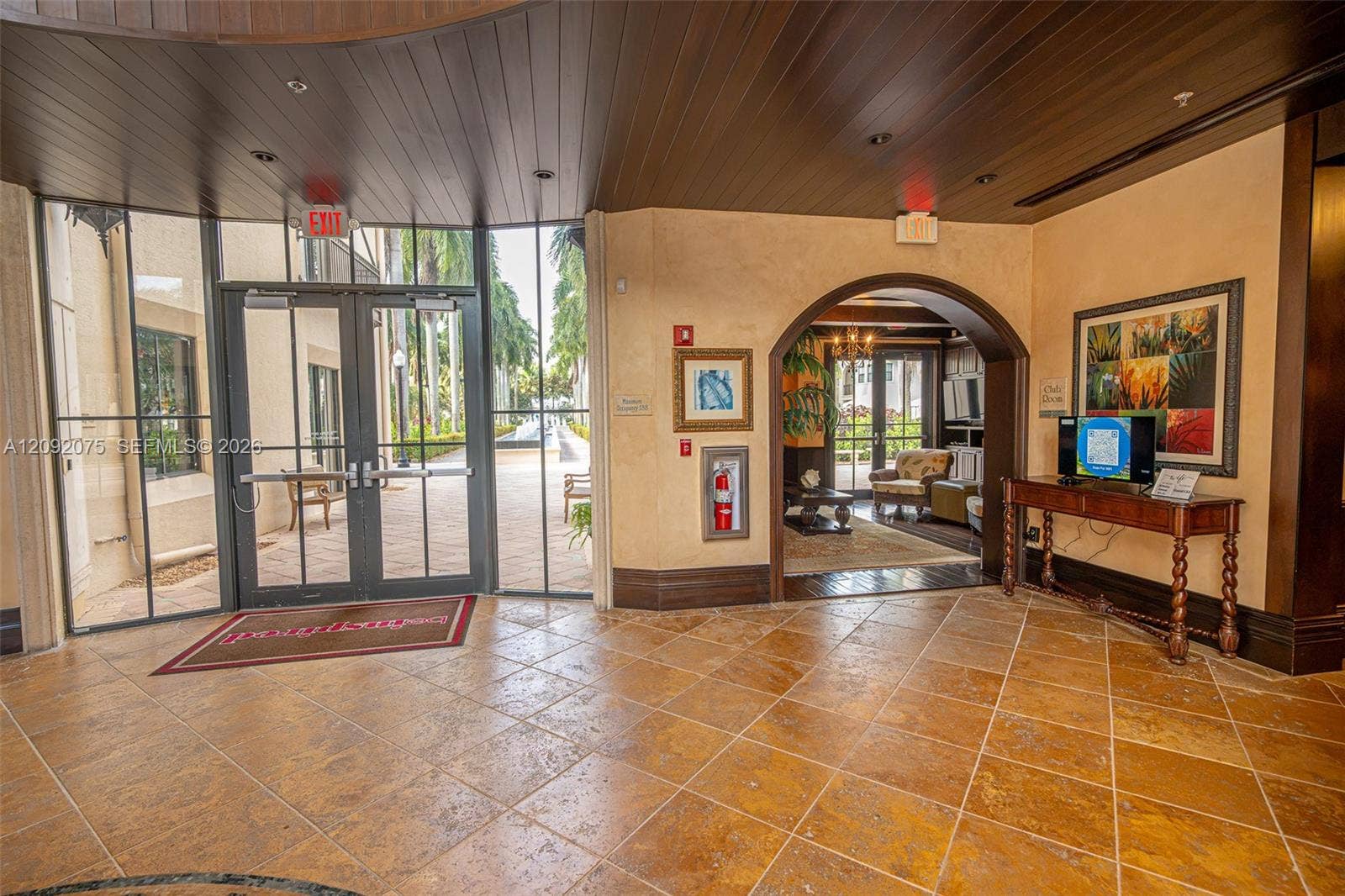 3055 NW 126th Avenue, #219, Sunrise, FL 33323 Tiled flooring with an arched entry, dark wood-paneled ceiling, and glass double doors