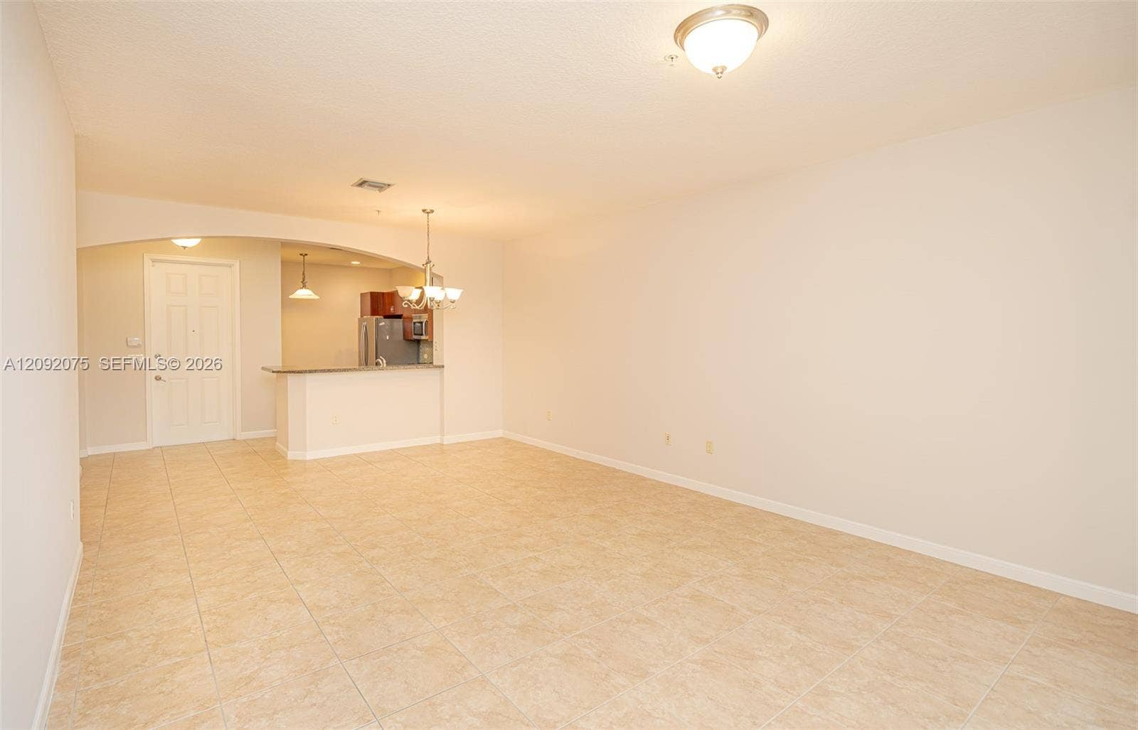 3055 NW 126th Avenue, #219, Sunrise, FL 33323 Tiled flooring throughout, an arched entryway, and a breakfast bar with a stone countertop