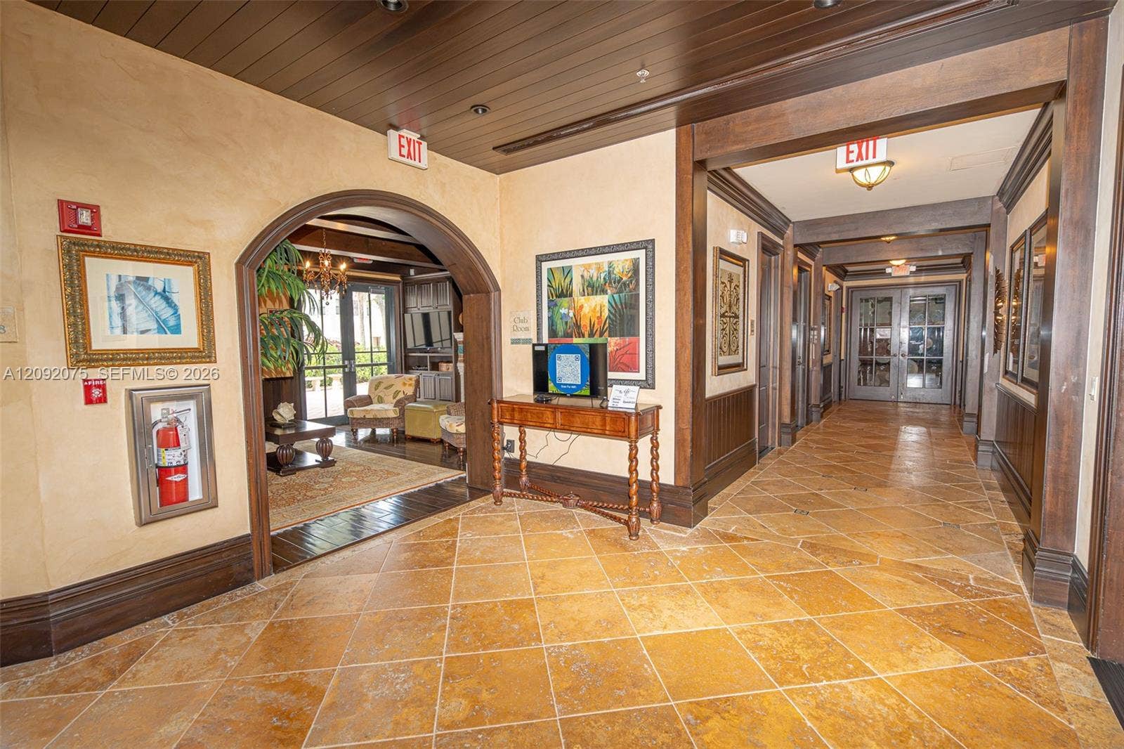3055 NW 126th Avenue, #219, Sunrise, FL 33323 Tiled flooring, dark wood trim, wood paneled ceiling, arched entryway, and double glass doors