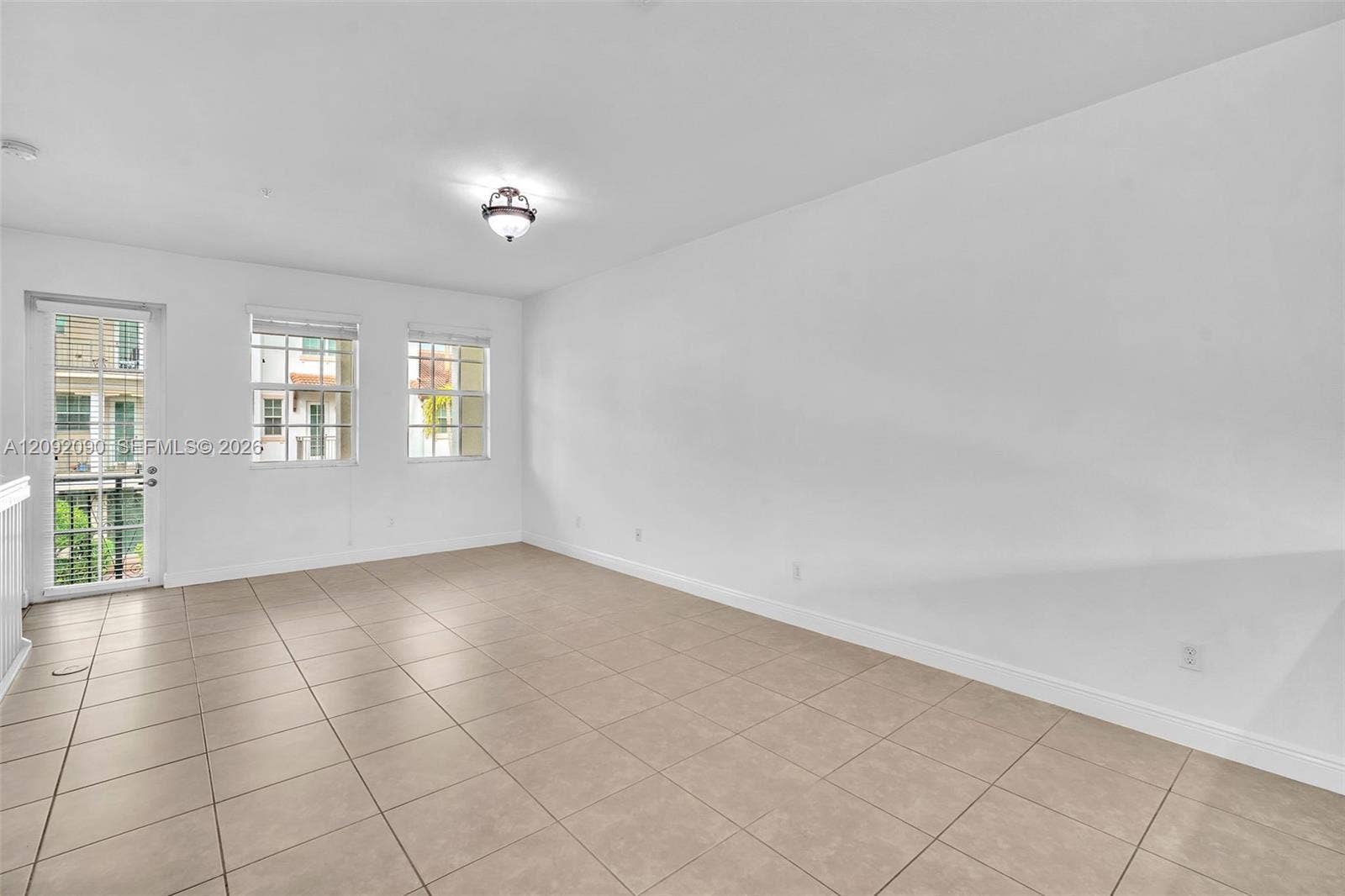 11979 SW 28th Court, Miramar, Miramar, FL 33025 Neutral-toned tile flooring, multi-pane windows, a glass-paneled door, and a ceiling-mounted light fixture