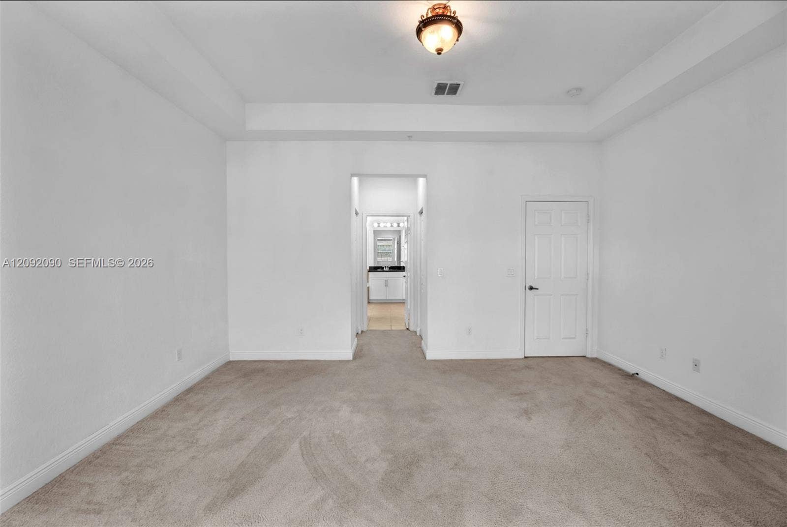 11979 SW 28th Court, Miramar, Miramar, FL 33025 Interior space featuring a recessed tray ceiling, neutral wall-to-wall carpeting, and a flush-mount light fixture