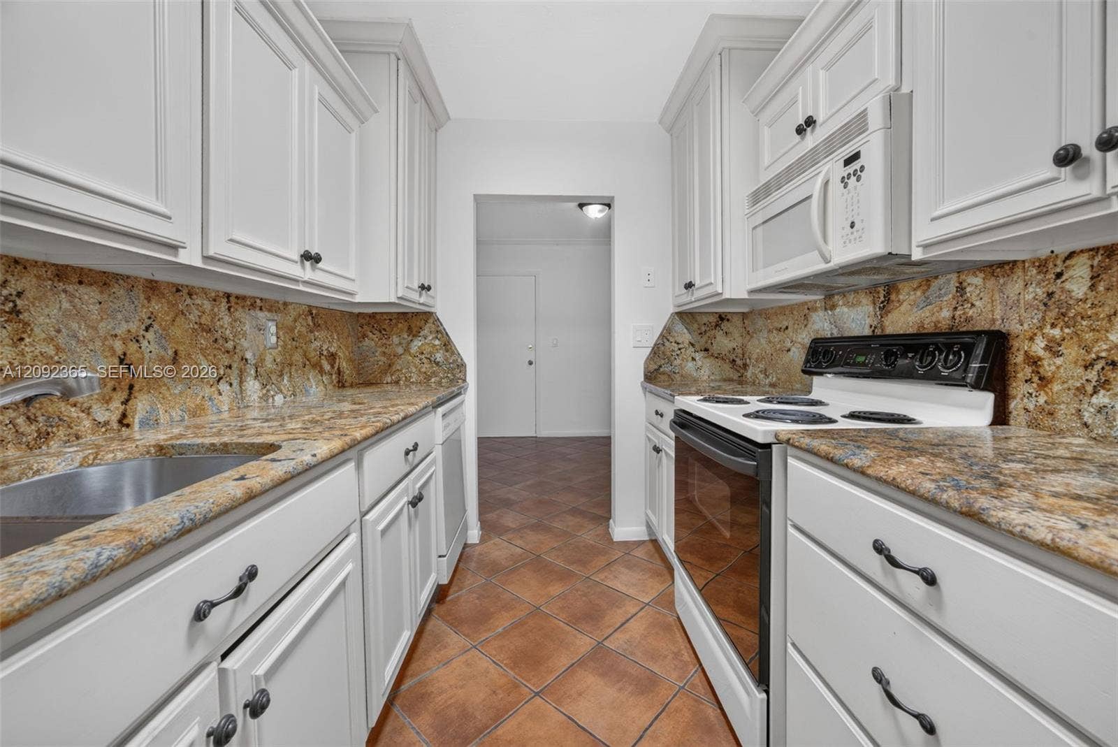 9356 SW 77th Avenue, #J7, Miami, FL 33156 Galley-style kitchen featuring wood cabinetry & granite countertops