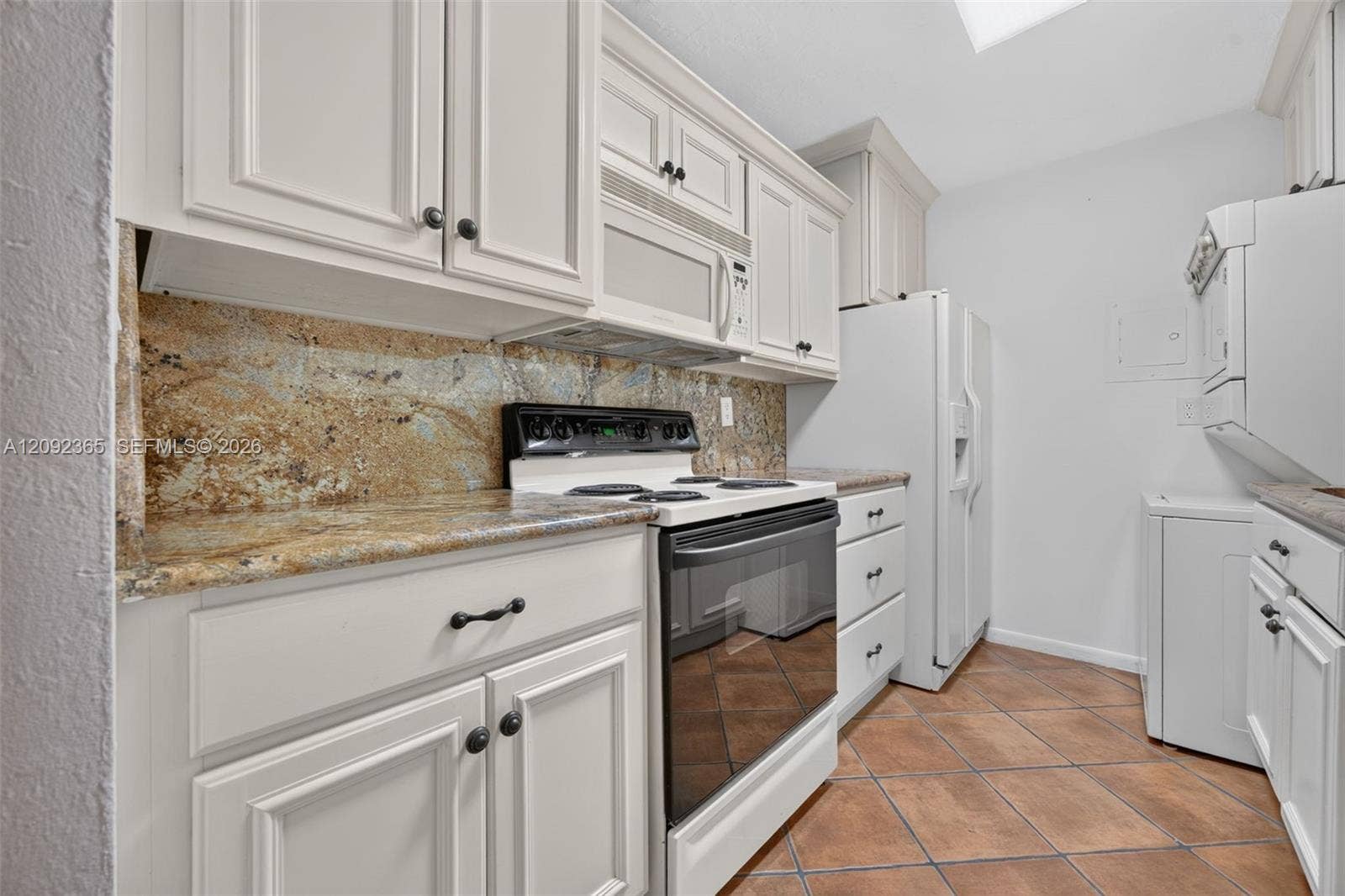 9356 SW 77th Avenue, #J7, Miami, FL 33156 Galley-style kitchen featuring wood cabinetry & granite countertops