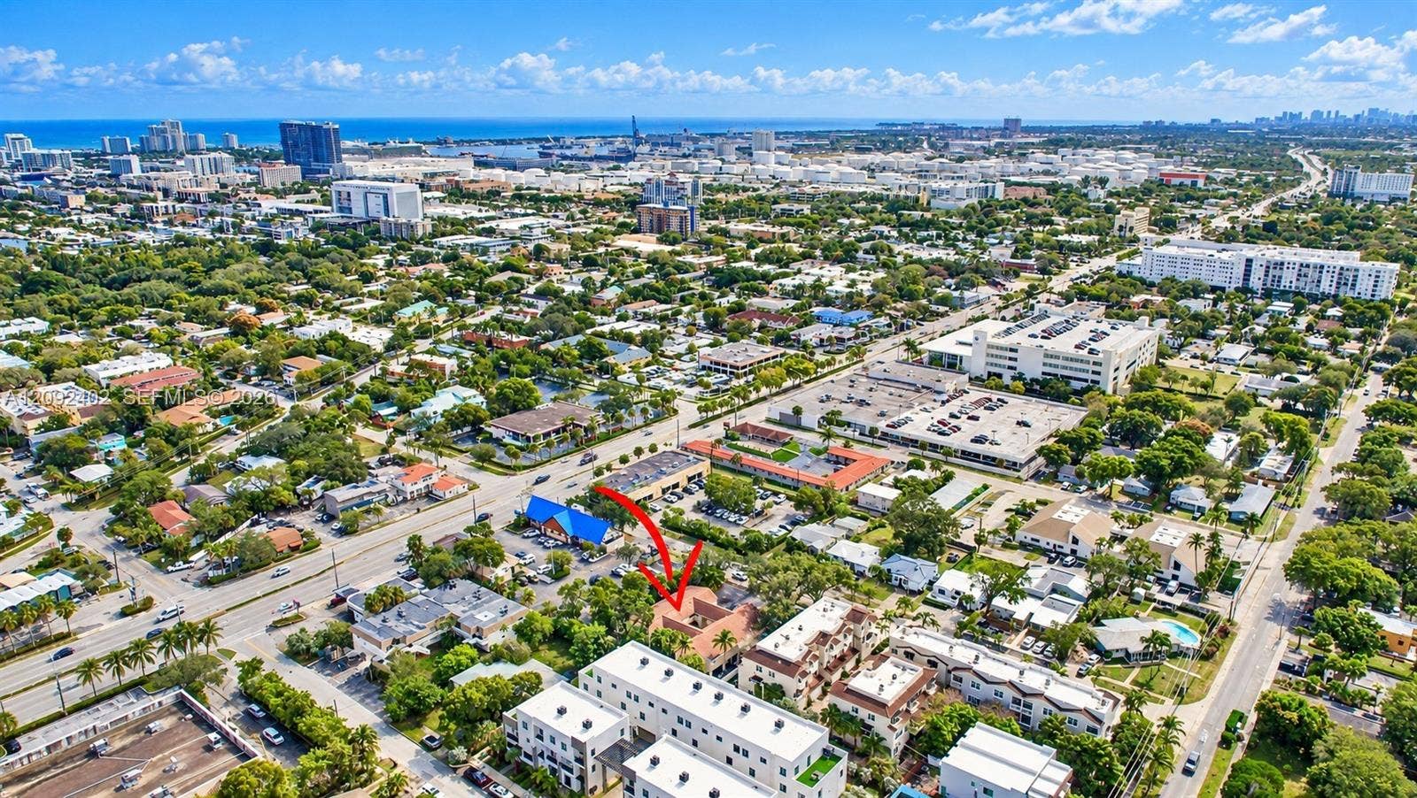 499 SE 13th Street, #7E, Fort Lauderdale, FL 33316 Aerial perspective of a multi-unit residential property featuring a tiled roof, structured hardscaping, and surrounding mature tree canopy