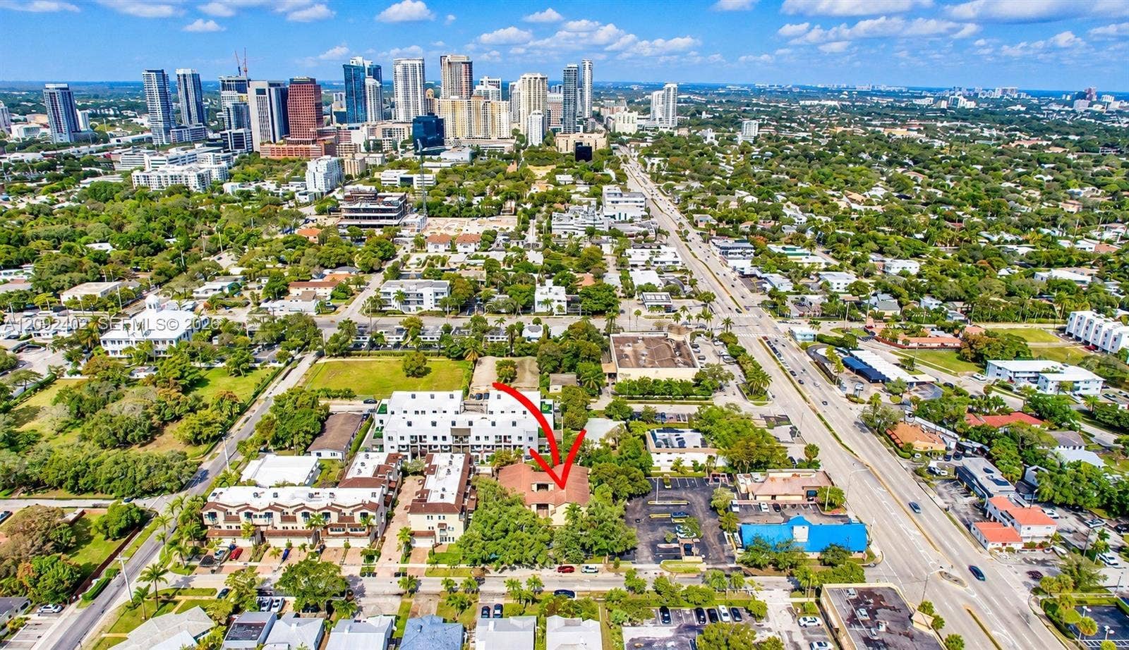 499 SE 13th Street, #7E, Fort Lauderdale, FL 33316 Aerial perspective featuring an urban lot with mature trees and a multi-unit building, situated within a metropolitan area