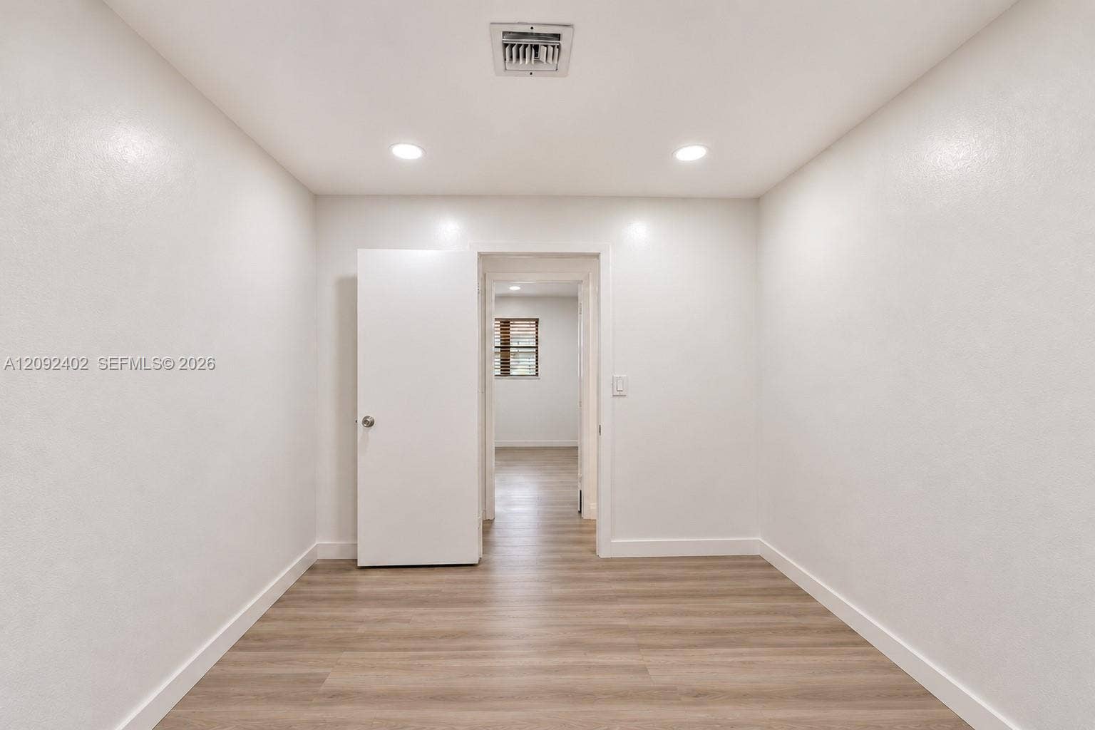 499 SE 13th Street, #7E, Fort Lauderdale, FL 33316 Interior space featuring light-toned wood-finish flooring, crisp neutral wall paint, recessed lighting, and a solid-core interior door