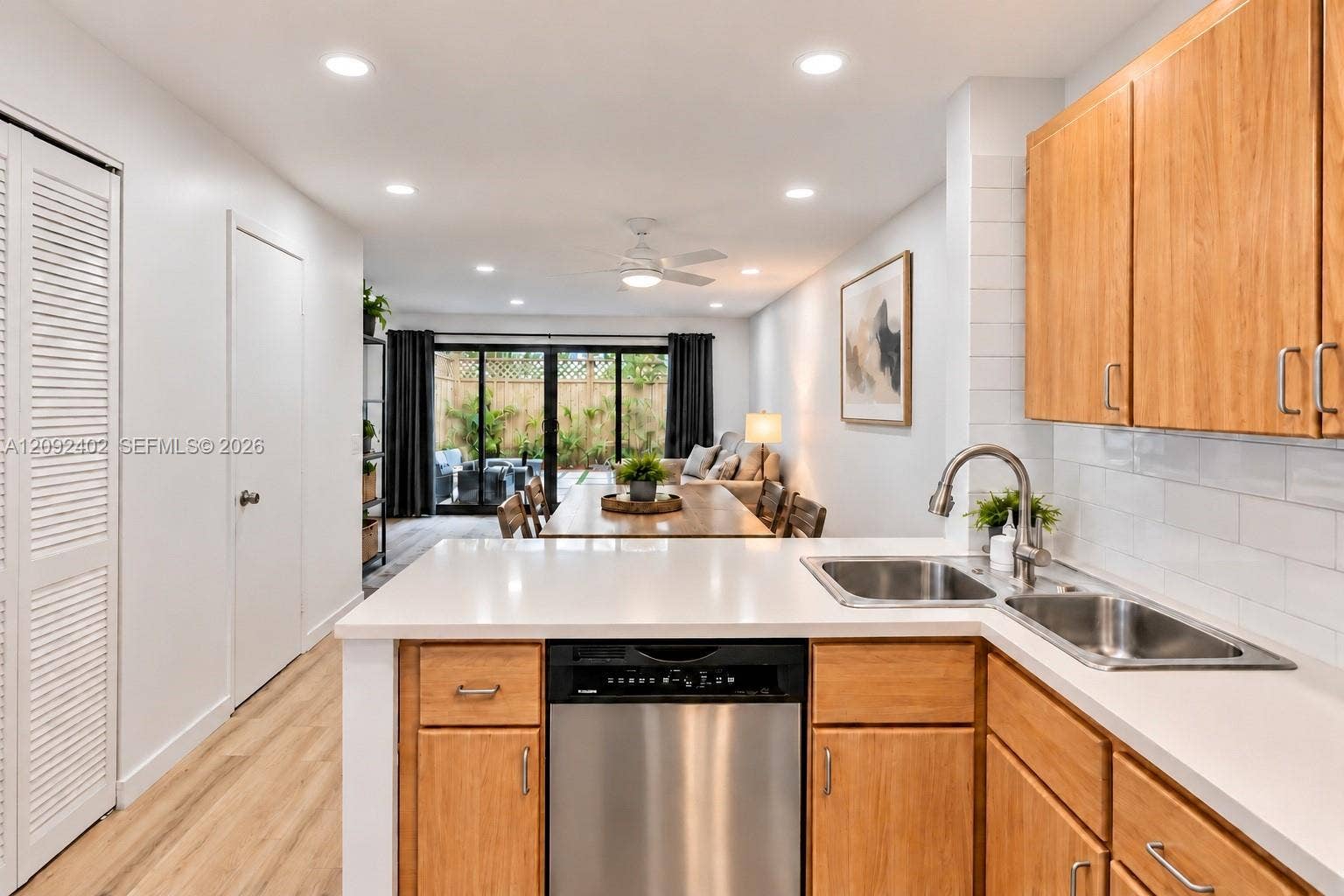 499 SE 13th Street, #7E, Fort Lauderdale, FL 33316 Kitchen featuring wood cabinetry, white countertops, a stainless steel dishwasher, an undermount double-basin sink with a gooseneck faucet, and white subway tile backsplash