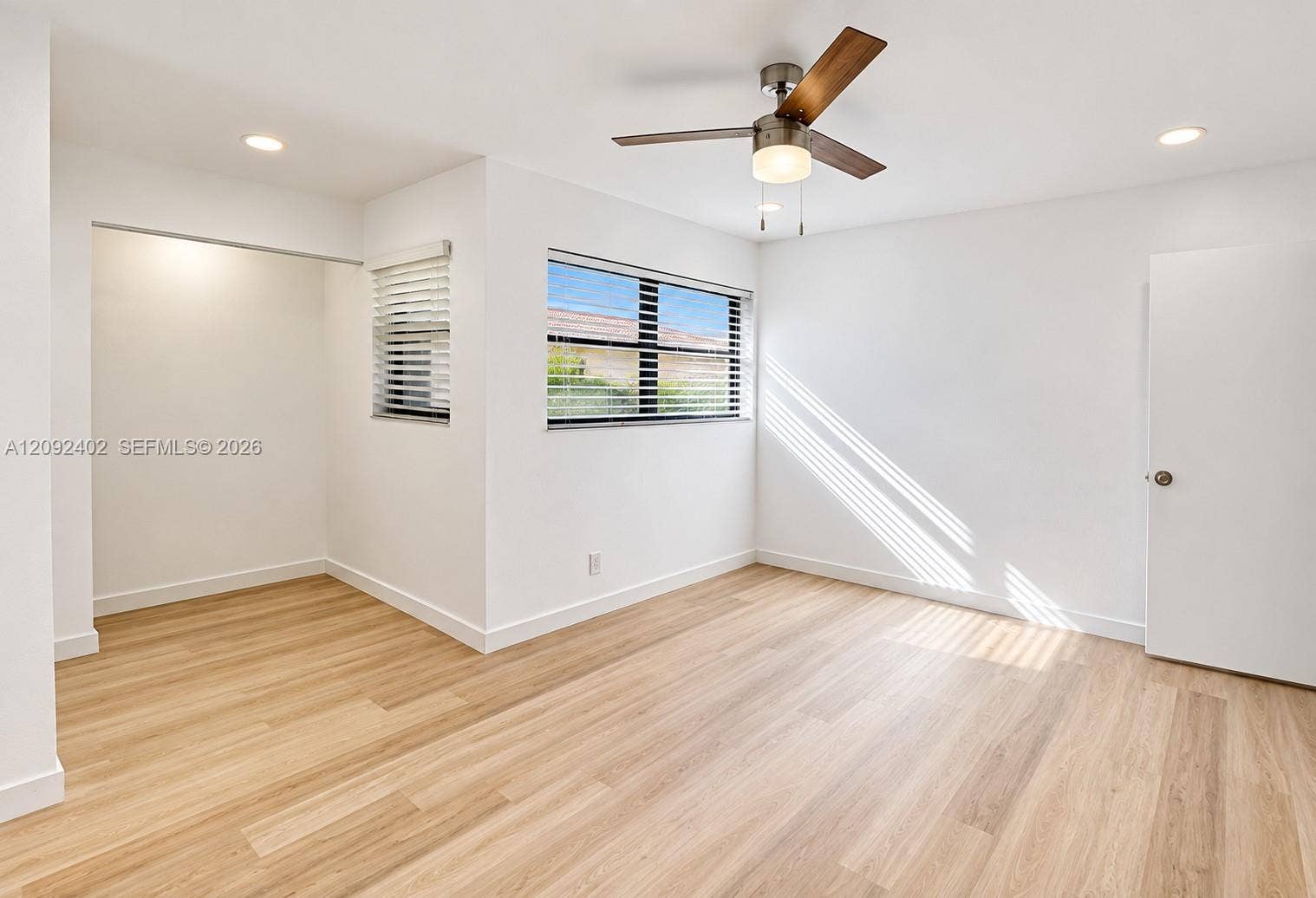 499 SE 13th Street, #7E, Fort Lauderdale, FL 33316 Neutral interior featuring wood-finish flooring, recessed lighting, a modern ceiling fan, and windows with integrated blinds
