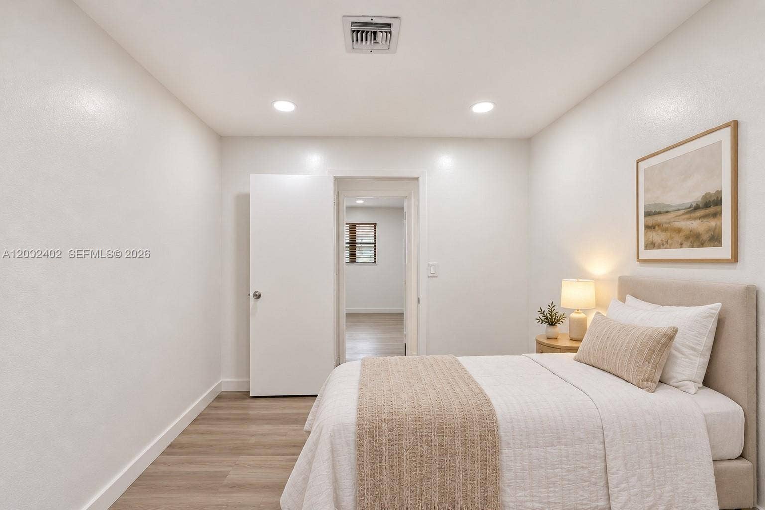 499 SE 13th Street, #7E, Fort Lauderdale, FL 33316 TV console & plants virtually staged for illustrative purposes. Neutral-toned walls, wood-finish flooring, recessed lighting, and a crisp white interior door