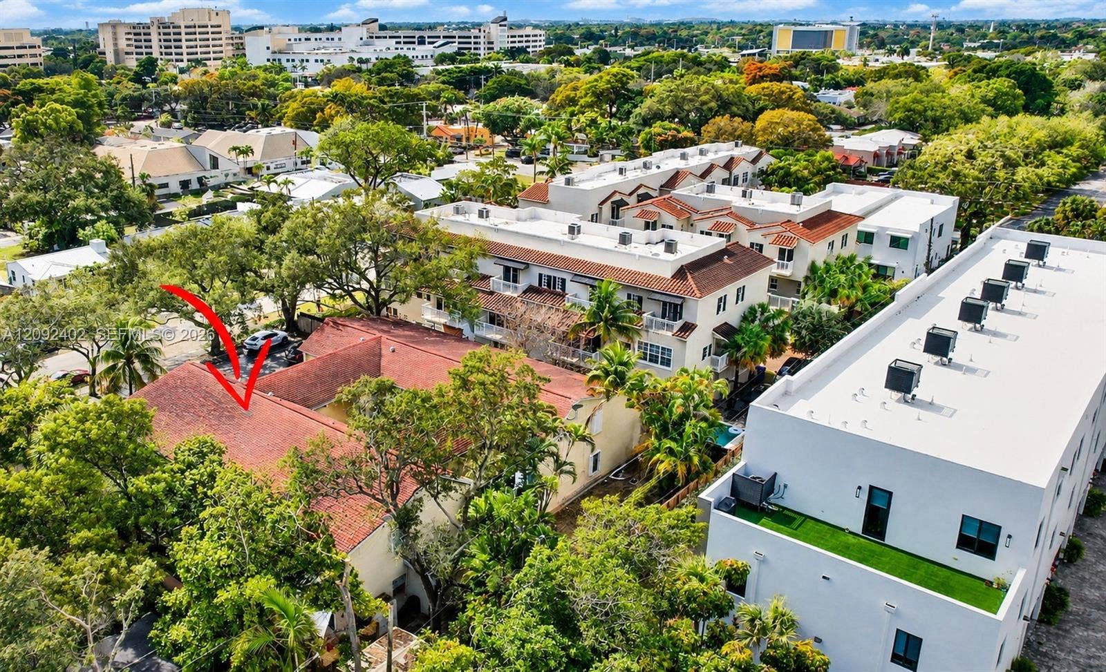 499 SE 13th Street, #7E, Fort Lauderdale, FL 33316 Aerial perspective featuring a multi-unit property with a multi-gabled terracotta tile roof, stucco exterior, and mature tree canopy landscaping