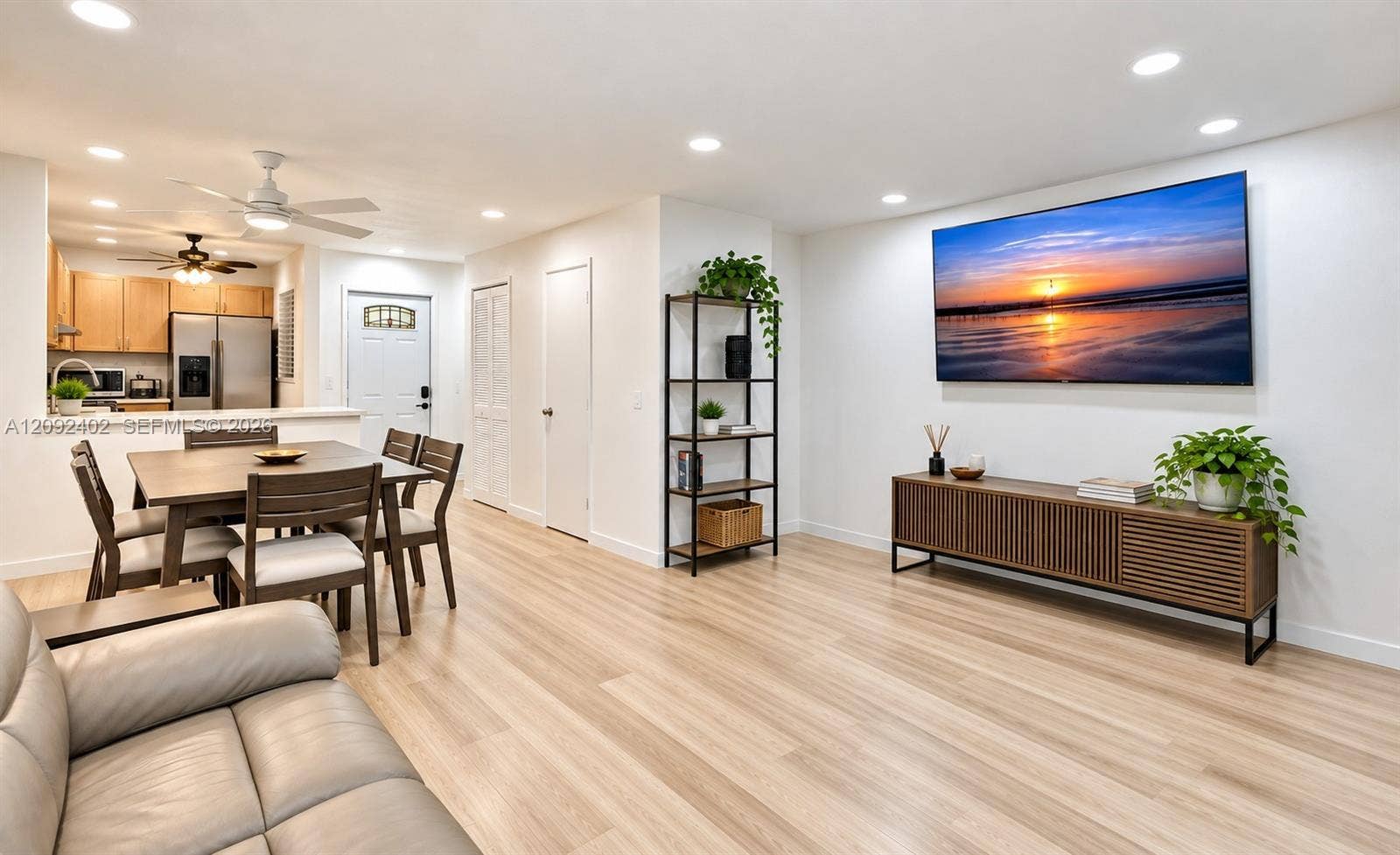 499 SE 13th Street, #7E, Fort Lauderdale, FL 33316 TV console & plants virtually staged for illustrative purposes. Open-concept interior featuring wood-finish flooring, recessed lighting, and a breakfast bar