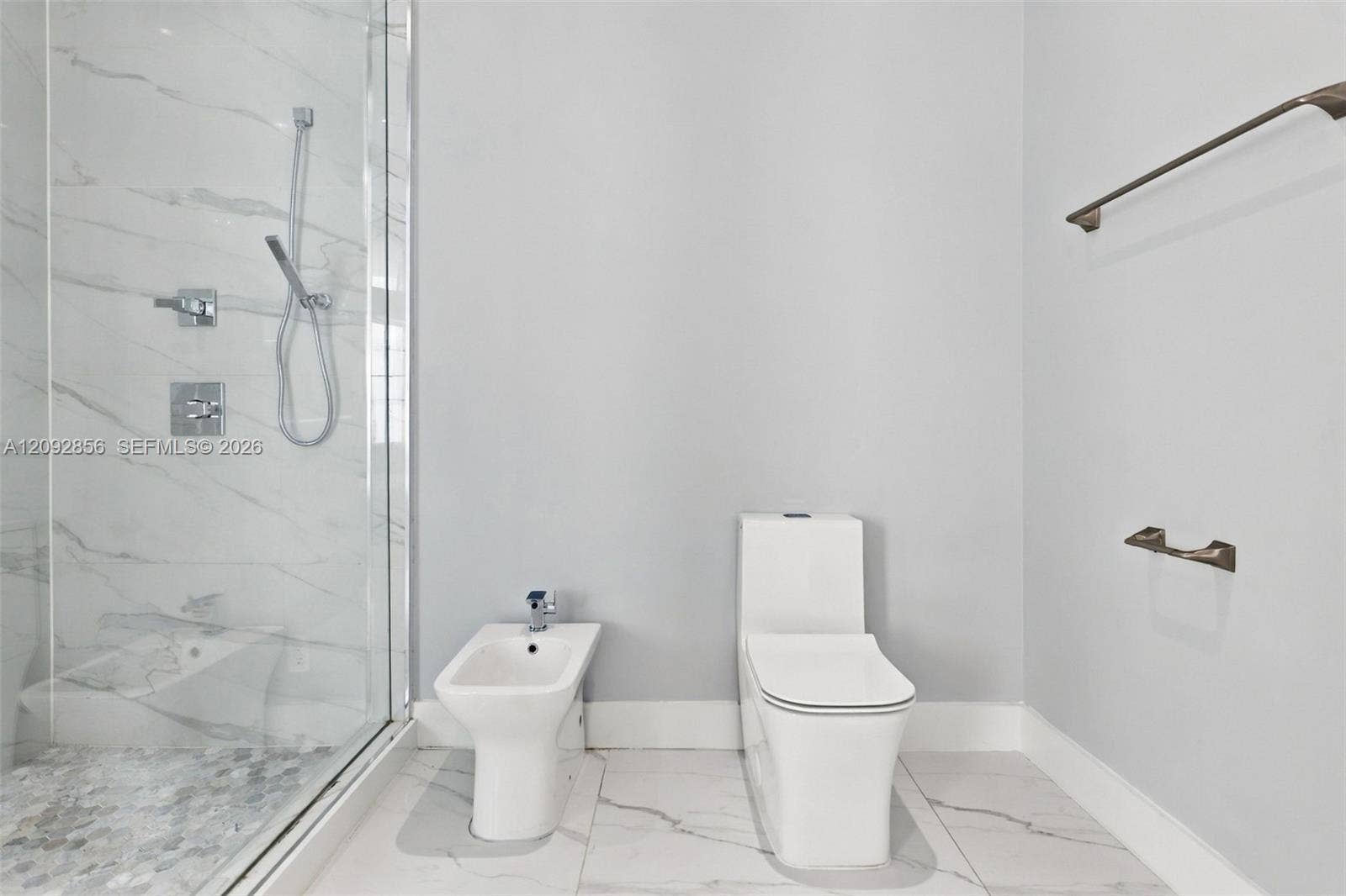 18919 SW 24th Street, #18919, Miramar, Miramar, FL 33029 Walk-in shower with stone-look wall tile and pebble-texture flooring, integrated bidet, dual-flush toilet, and metal wall-mounted fixtures