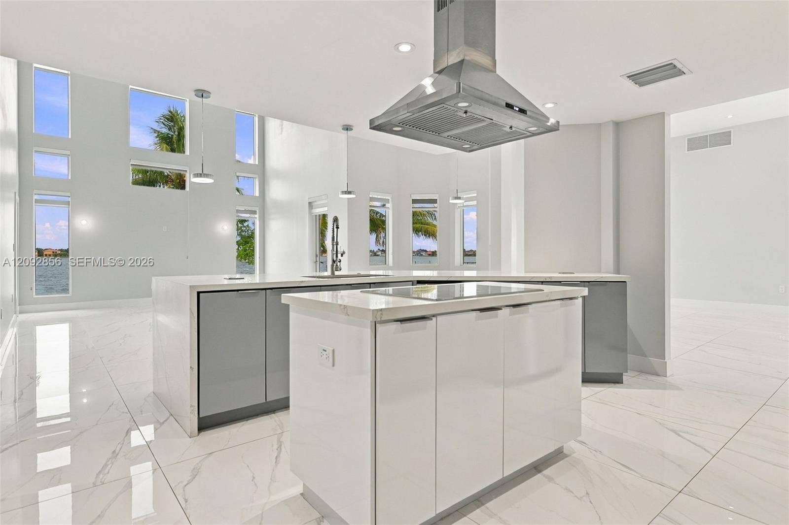 18919 SW 24th Street, #18919, Miramar, Miramar, FL 33029 Kitchen featuring a central island with a solid surface countertop, stainless steel vent hood, floor-to-ceiling windows, high-gloss cabinetry, and large-format tile flooring