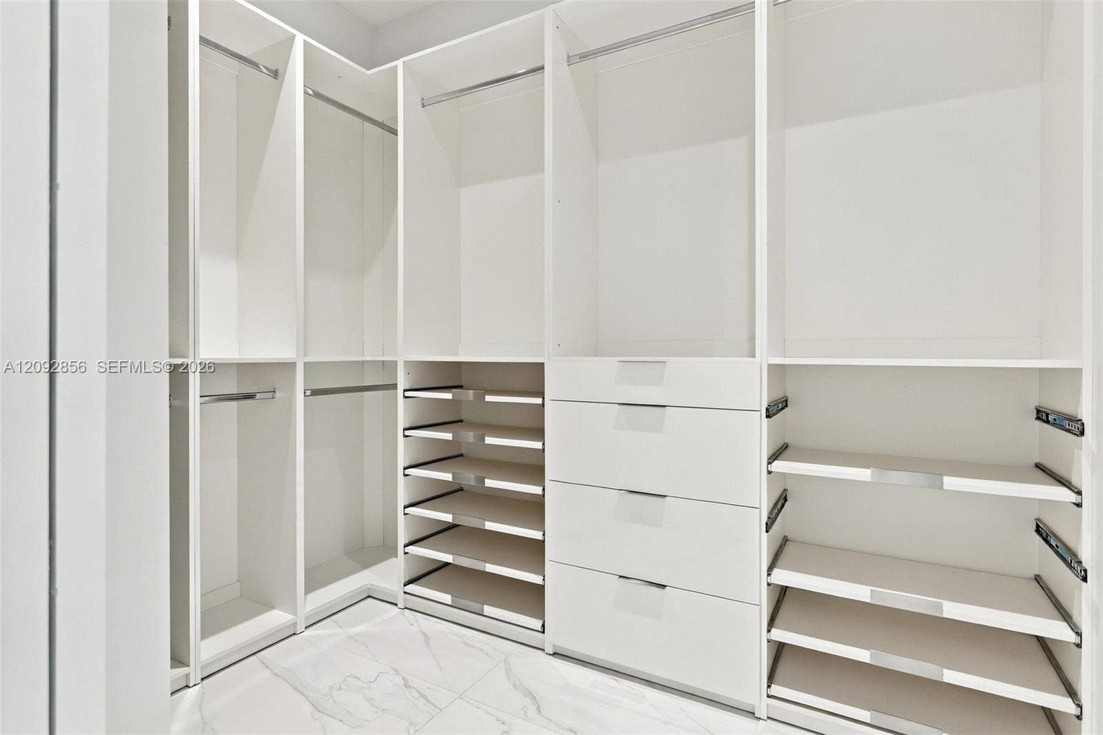 18919 SW 24th Street, #18919, Miramar, Miramar, FL 33029 Custom built-in storage system featuring white cabinetry, multiple hanging sections, integrated shelving, and a four-drawer stack, complemented by large-format tile flooring