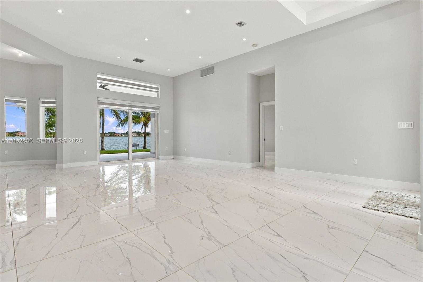18919 SW 24th Street, #18919, Miramar, Miramar, FL 33029 Spacious interior featuring large-format stone-finish tile flooring, vaulted ceilings, recessed lighting, and expansive glass sliding doors