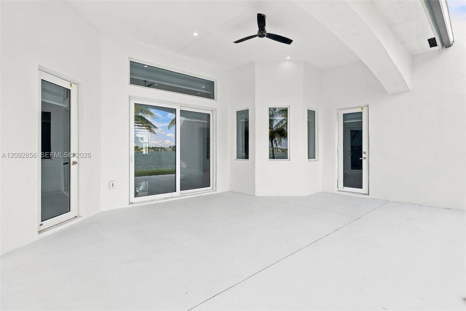 18919 SW 24th Street, #18919, Miramar, Miramar, FL 33029 Covered patio featuring a high vaulted ceiling, integrated ceiling fan, recessed lighting, expansive glass sliding doors, and multiple casement windows