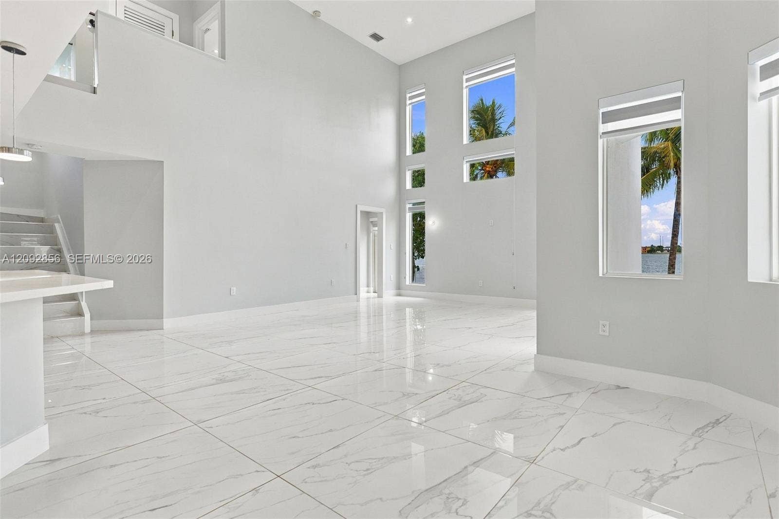 18919 SW 24th Street, #18919, Miramar, Miramar, FL 33029 Double-height ceilings, large-format polished stone-finish floor tiles, multi-level oversized windows, and a built-in staircase with a glass railing