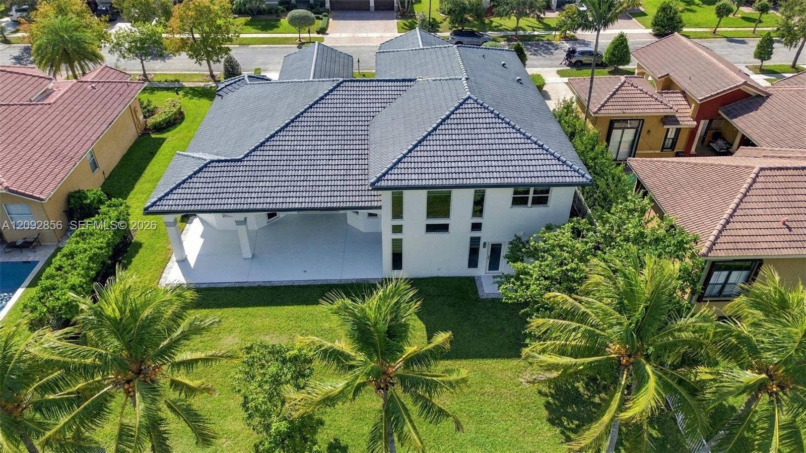 18919 SW 24th Street, #18919, Miramar, Miramar, FL 33029 Two-story residence featuring a tile roof, light-toned exterior finish, covered patio, and landscaped yard with mature palms