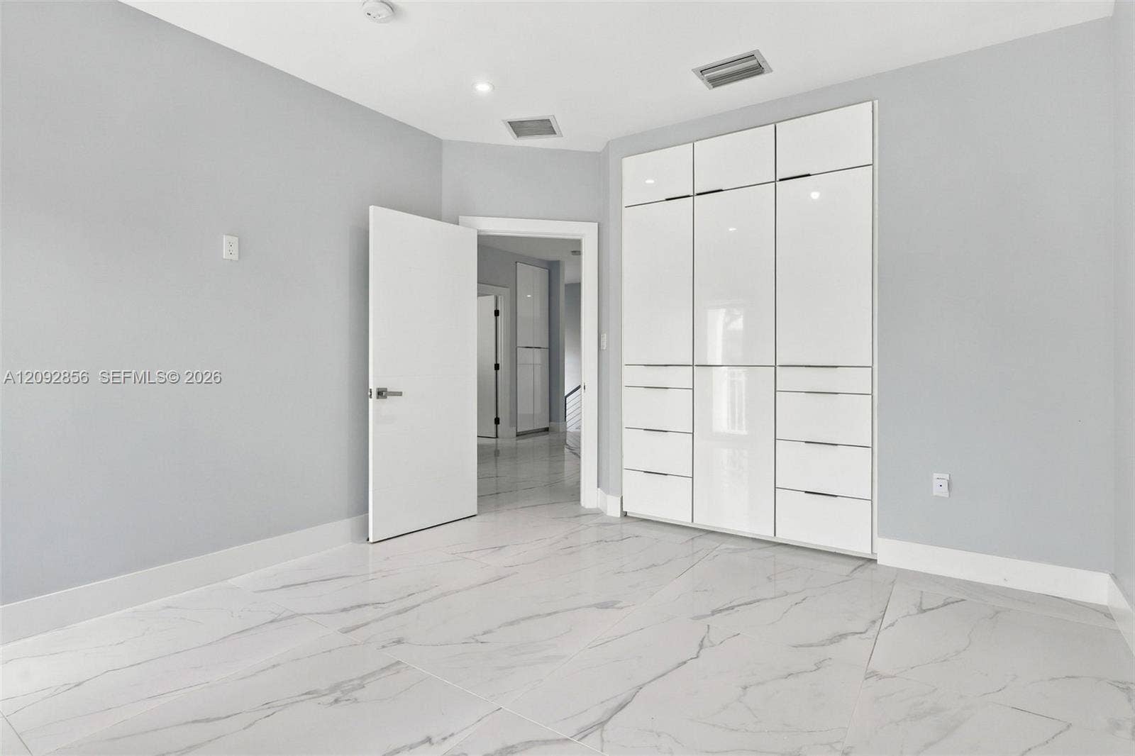 18919 SW 24th Street, #18919, Miramar, Miramar, FL 33029 5th bedroom (balcony) - 2nd floor - Large-format tile flooring with marble-style veining and full-height built-in cabinetry featuring high-gloss, flat-panel doors and integrated hardware
