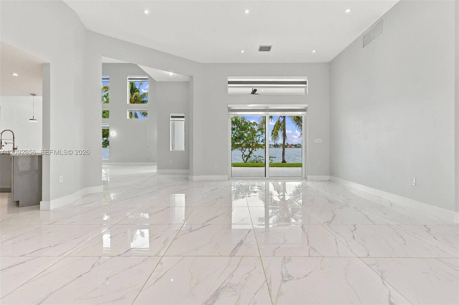 18919 SW 24th Street, #18919, Miramar, Miramar, FL 33029 Open-concept interior featuring large-format polished tile flooring, recessed lighting, multi-level window configurations, and sliding glass doors with water frontage
