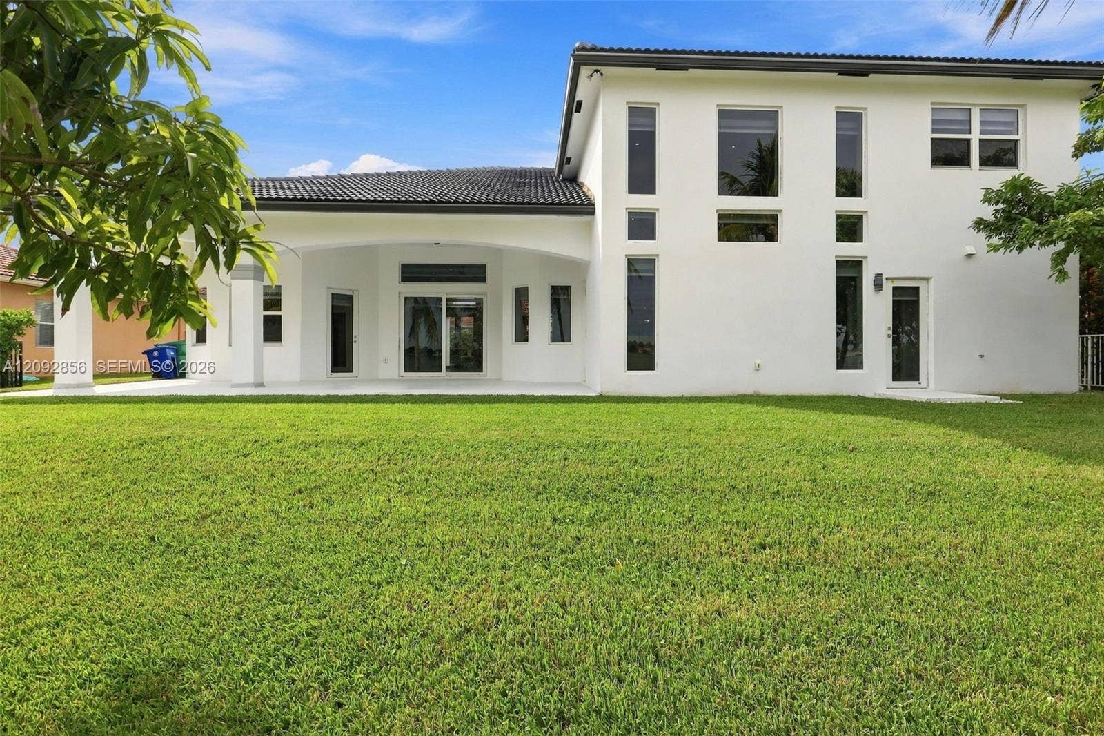 18919 SW 24th Street, #18919, Miramar, Miramar, FL 33029 Two-story exterior featuring a stucco facade, tiled roof, covered patio, and multi-paned vertical windows