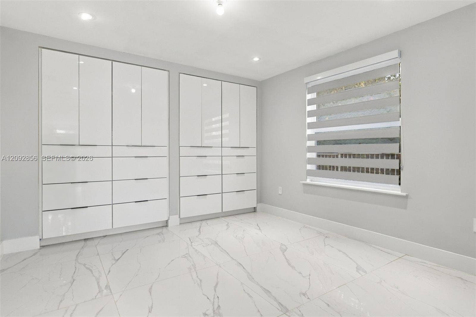 18919 SW 24th Street, #18919, Miramar, Miramar, FL 33029 2nd bedroom - 1st floor - Glossy white built-in cabinetry featuring integrated drawers, large-format tile flooring with a veined pattern, and recessed ceiling lighting