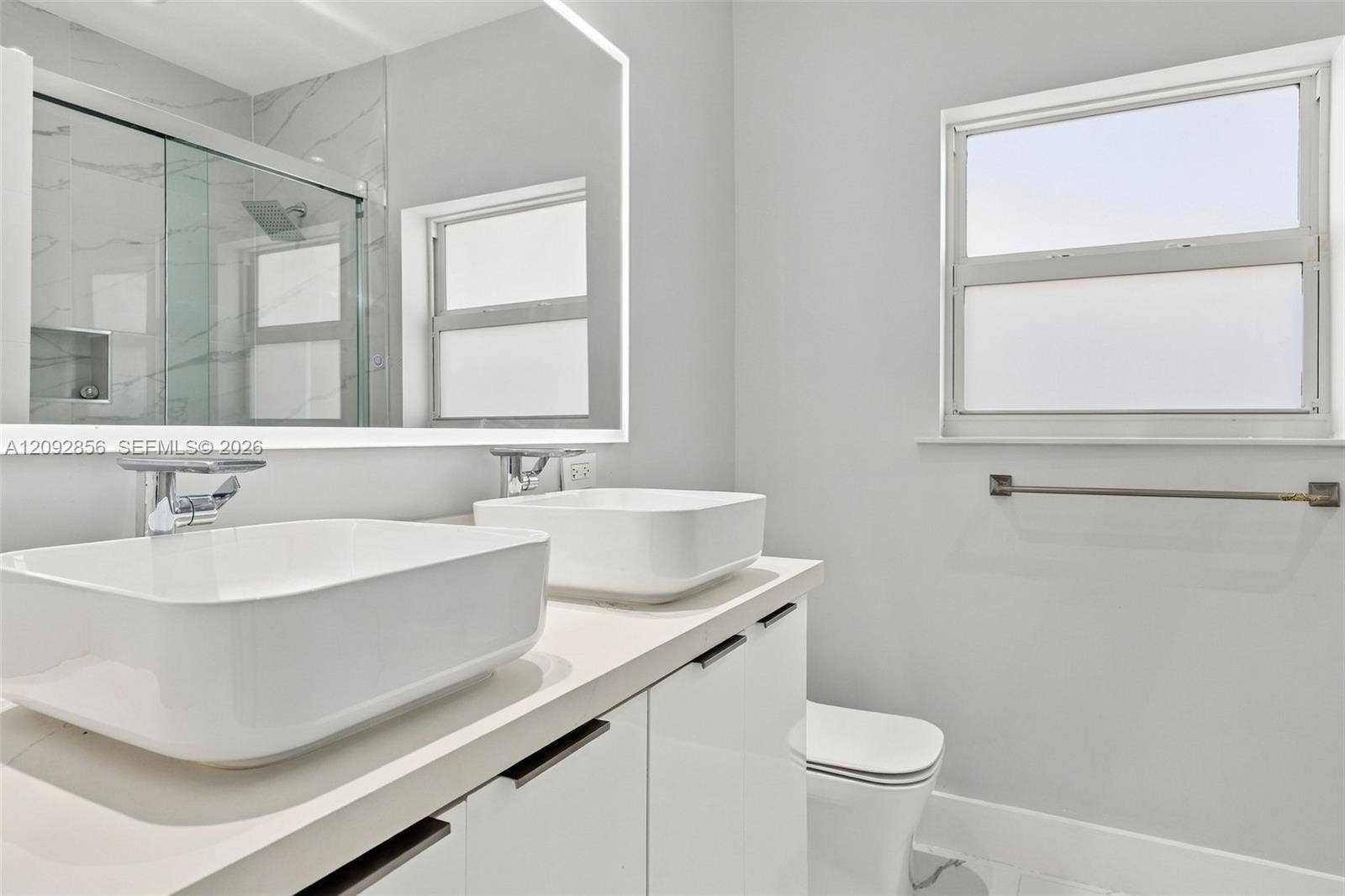 18919 SW 24th Street, #18919, Miramar, Miramar, FL 33029 3rd bathroom - loft - Dual vessel sinks with chrome faucets, quartz-surfaced vanity, large backlit mirror, and glass-enclosed shower with tiled walls