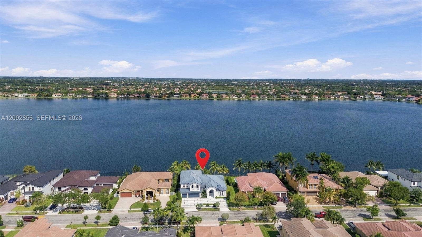 18919 SW 24th Street, #18919, Miramar, Miramar, FL 33029 Waterfront property featuring direct water access, multi-story architectural design, paver driveway, and mature palm trees