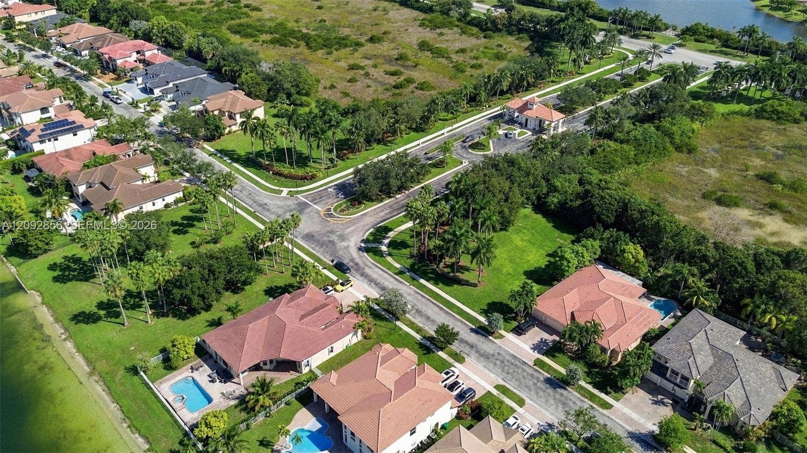 18919 SW 24th Street, #18919, Miramar, Miramar, FL 33029 Aerial perspective of a residential community featuring multi-hipped tile roofing, paved streets, private swimming pools, and mature landscaping throughout the grounds